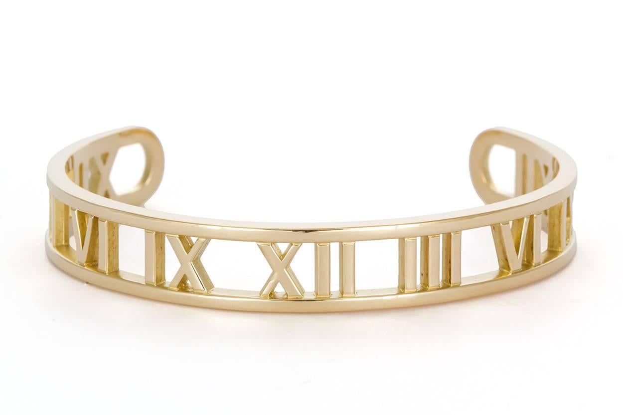 We are pleased to offer this Tiffany & Co. Open ATLAS Roman Numeral 18k Yellow Gold Cuff Bracelet. The cuff style Open Atlas has become rare and hard to find as Tiffany's no longer sells this style. Streamlined and modern, the Atlas collection