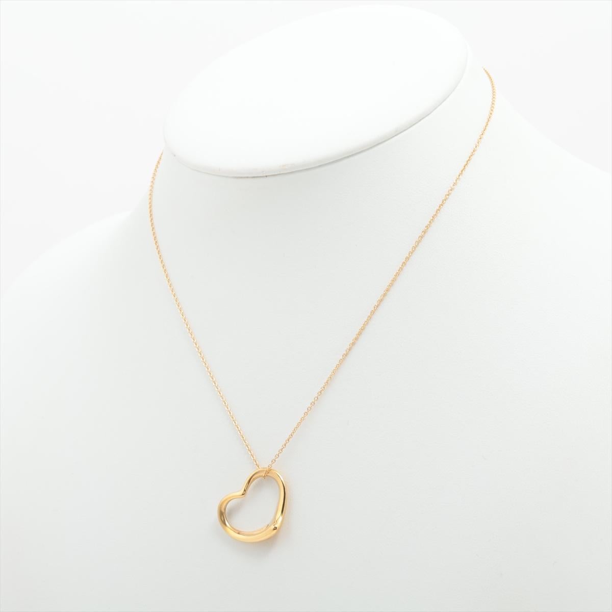 The Tiffany & Co. Open Heart Pendant Necklace in Gold is a stunning jewelry piece that embodies elegance and sophistication. The necklace features a delicate open heart-shaped pendant suspended from a dainty gold chain. The pendant's design is