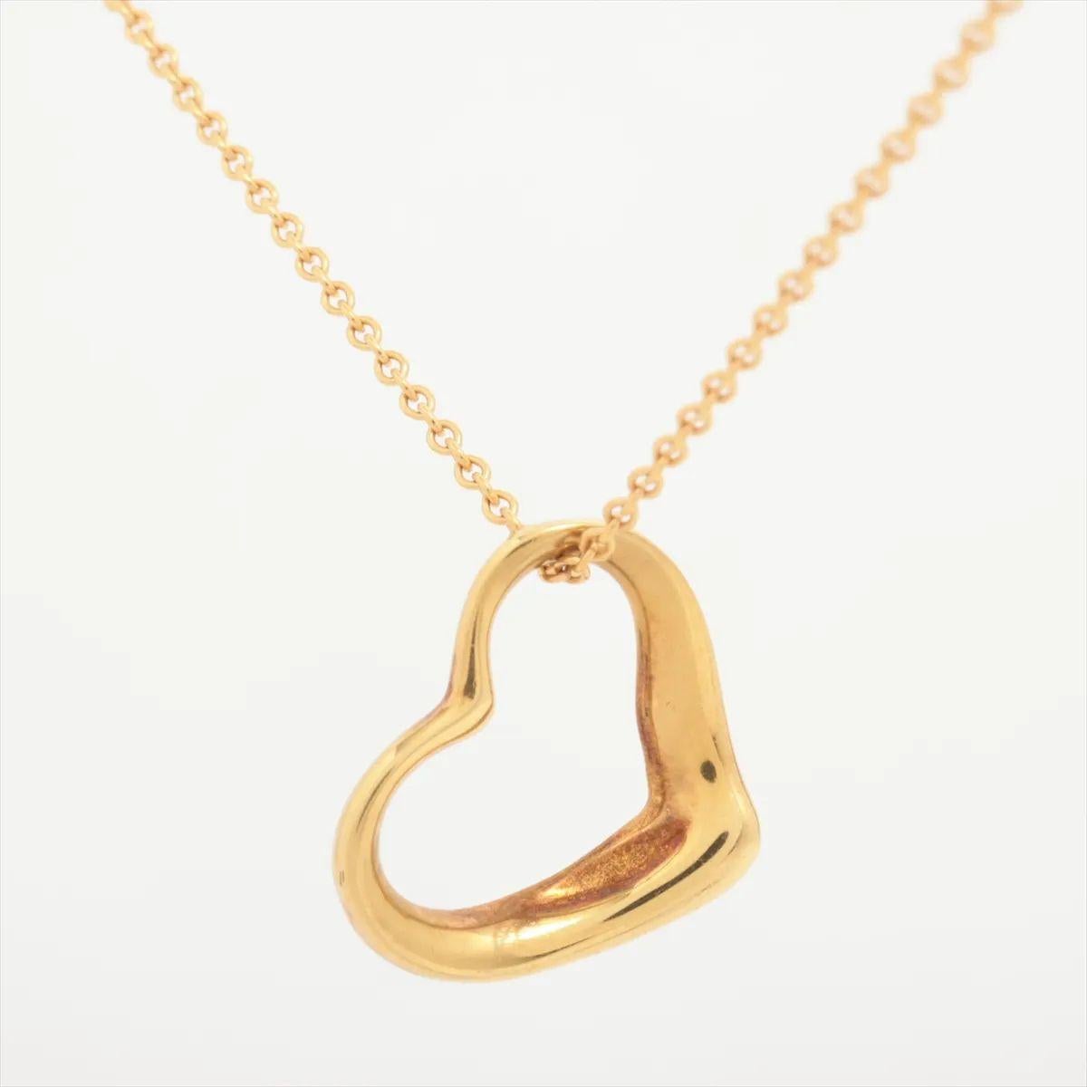 The Tiffany & Co. Open Heart Pendant Necklace in Gold is a stunning jewelry piece that embodies elegance and sophistication. The necklace features a delicate open heart-shaped pendant suspended from a dainty gold chain. The pendant's design is