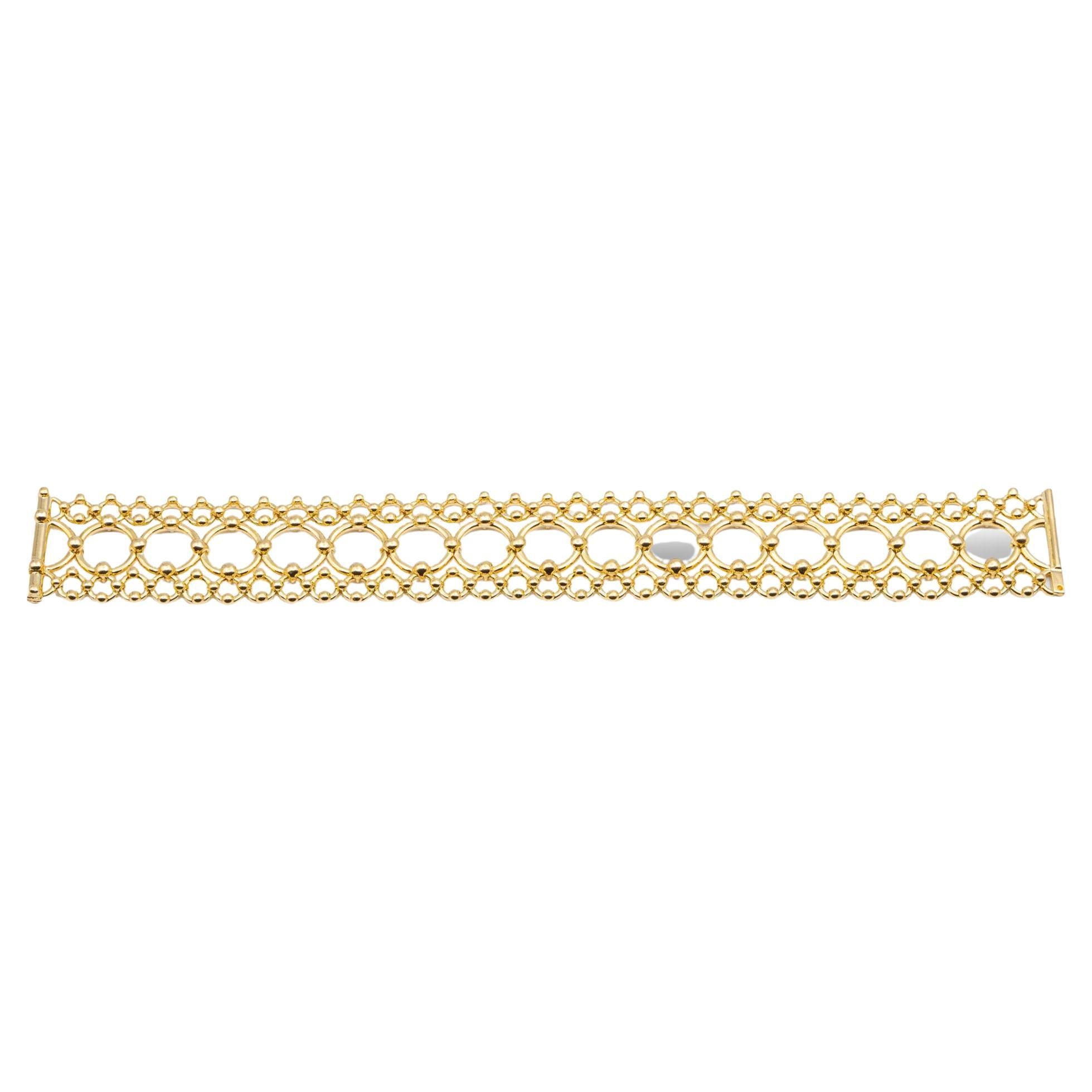 Vintage Tiffany & Co. Open-Scroll Round link design design Cleopatra bracelet finely crafted in 18 Karat yellow gold with Slide lock clasp. Bracelet is flexible, sits flat on the wrist and measures one inch wide. Fully hallmarked with logo and metal