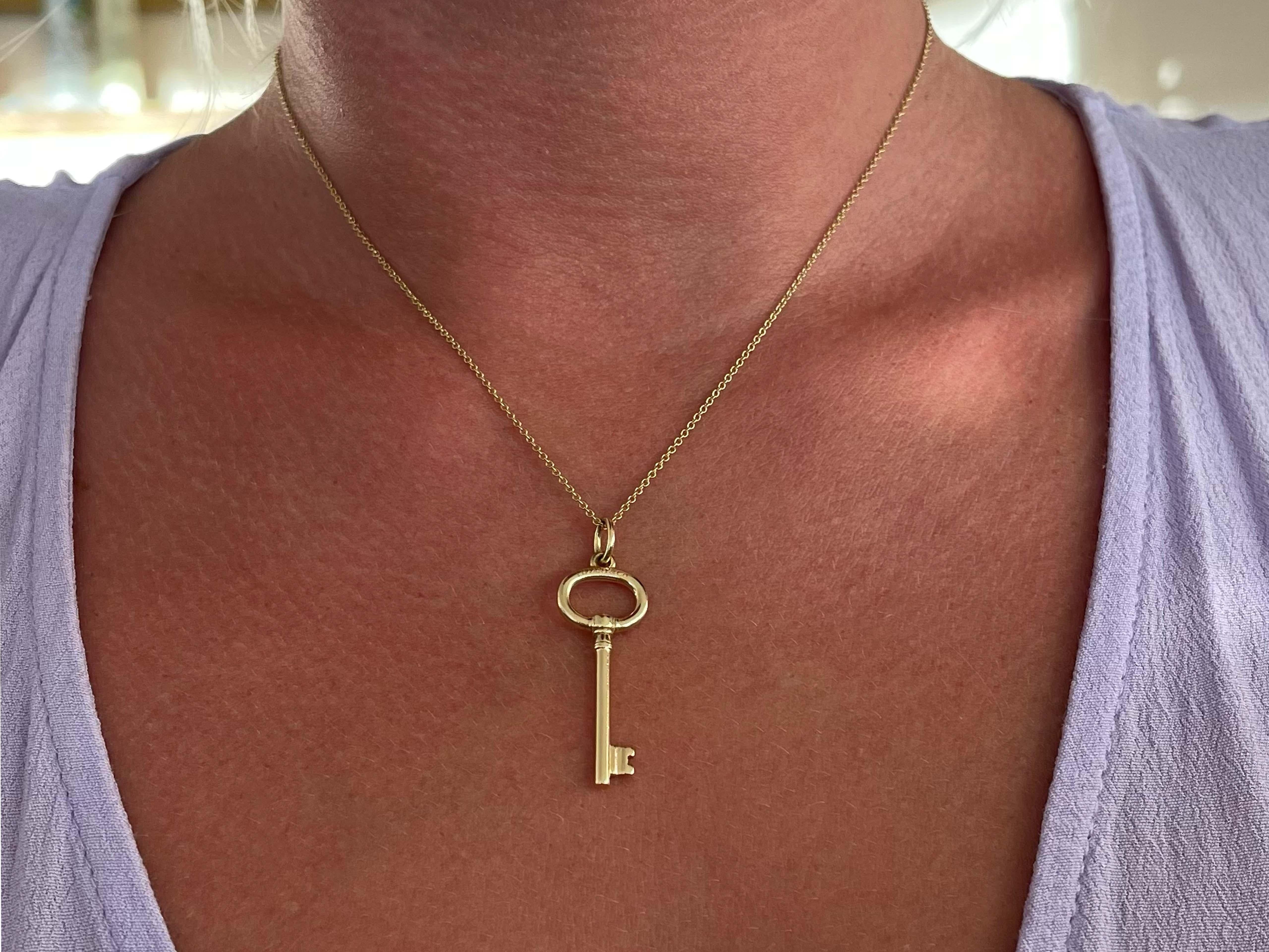 This key pendant necklace is an ageless classic design by Tiffany & Co. The key design comes in various different models, however the oval key pendant is the most iconic and classic of the collection. This pendant and chain is crafted in 18k yellow