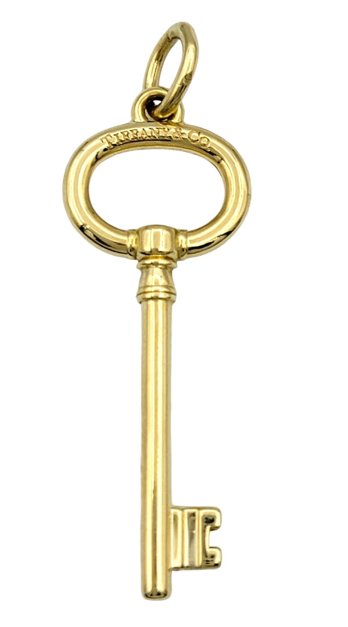 Unlock timeless elegance with this exquisite Tiffany & Co. oval key pendant, a symbol of sophistication and style. Crafted in lustrous 18 karat yellow gold, this pendant embodies Tiffany’s renowned craftsmanship and iconic design. The sleek,