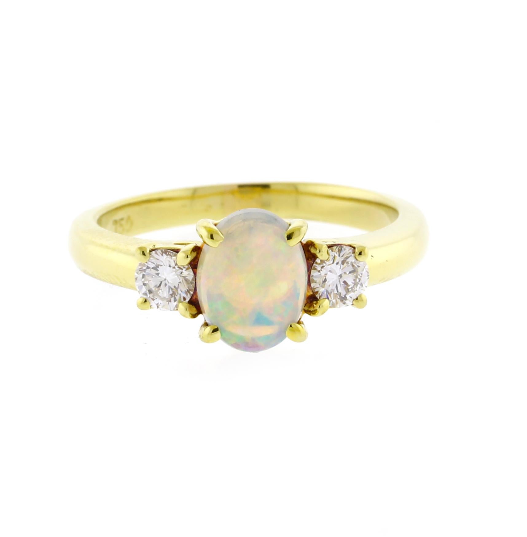Elevate your jewelry collection with the Tiffany & Co. oval opal and diamond ring, a breathtaking design that embodies timeless elegance and refined artistry. At the center rests a luminous oval opal measuring 7.7 x 5mm, radiating ethereal flashes