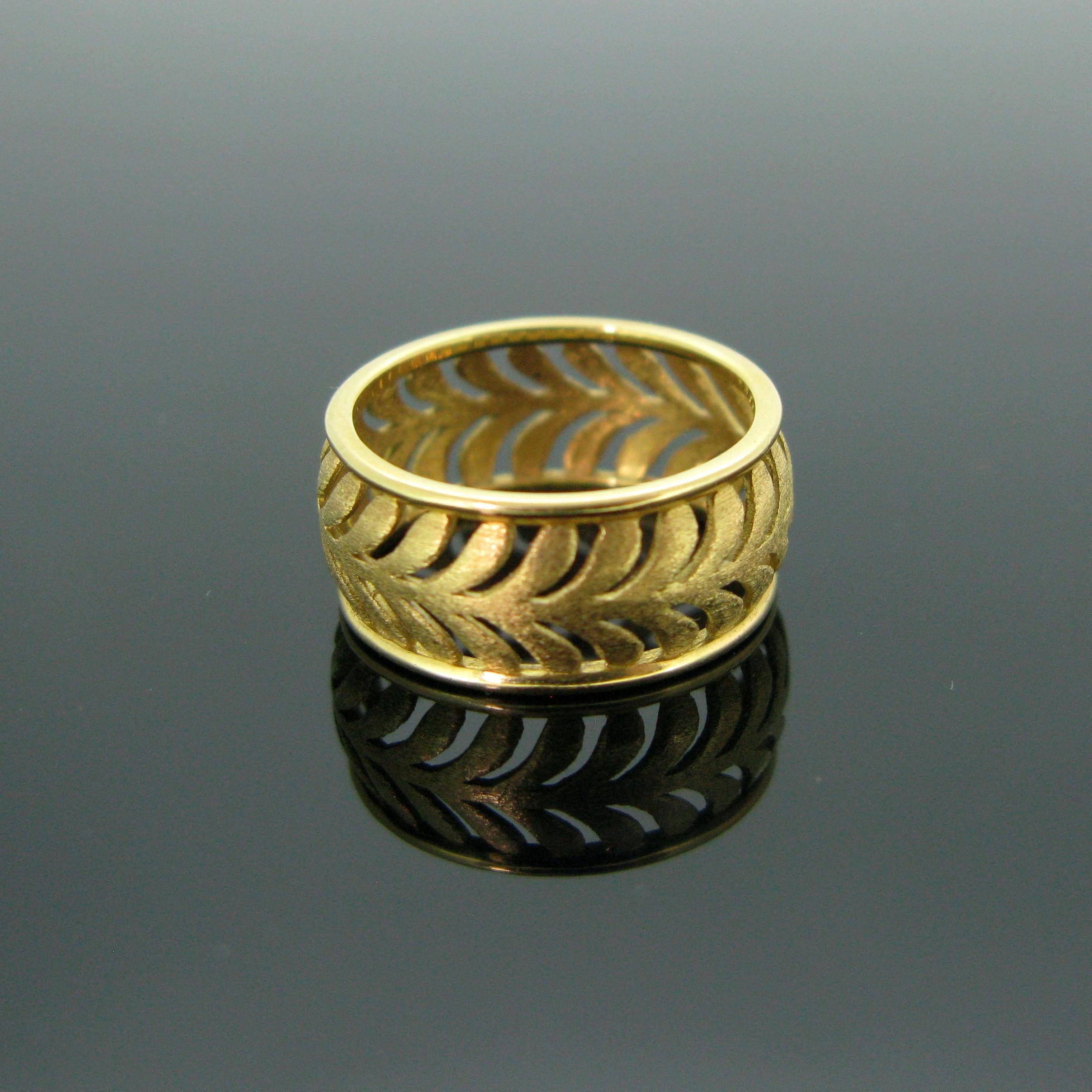 This 18kt yellow gold ring was made by Tiffany & Co from the collection Paloma Picasso. The motif on the shank resembles a palm leaf and the gold is brushed. It could be given as wedding band or simply an everyday gold band. It is signed inside the