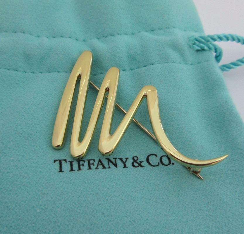 TIFFANY & Co. Paloma Picasso 18K Gold Scribble Pin Brooch 

Metal: 18K Yellow Gold 
Weight: 9.60 grams 
Measurement: 49mm(1.93