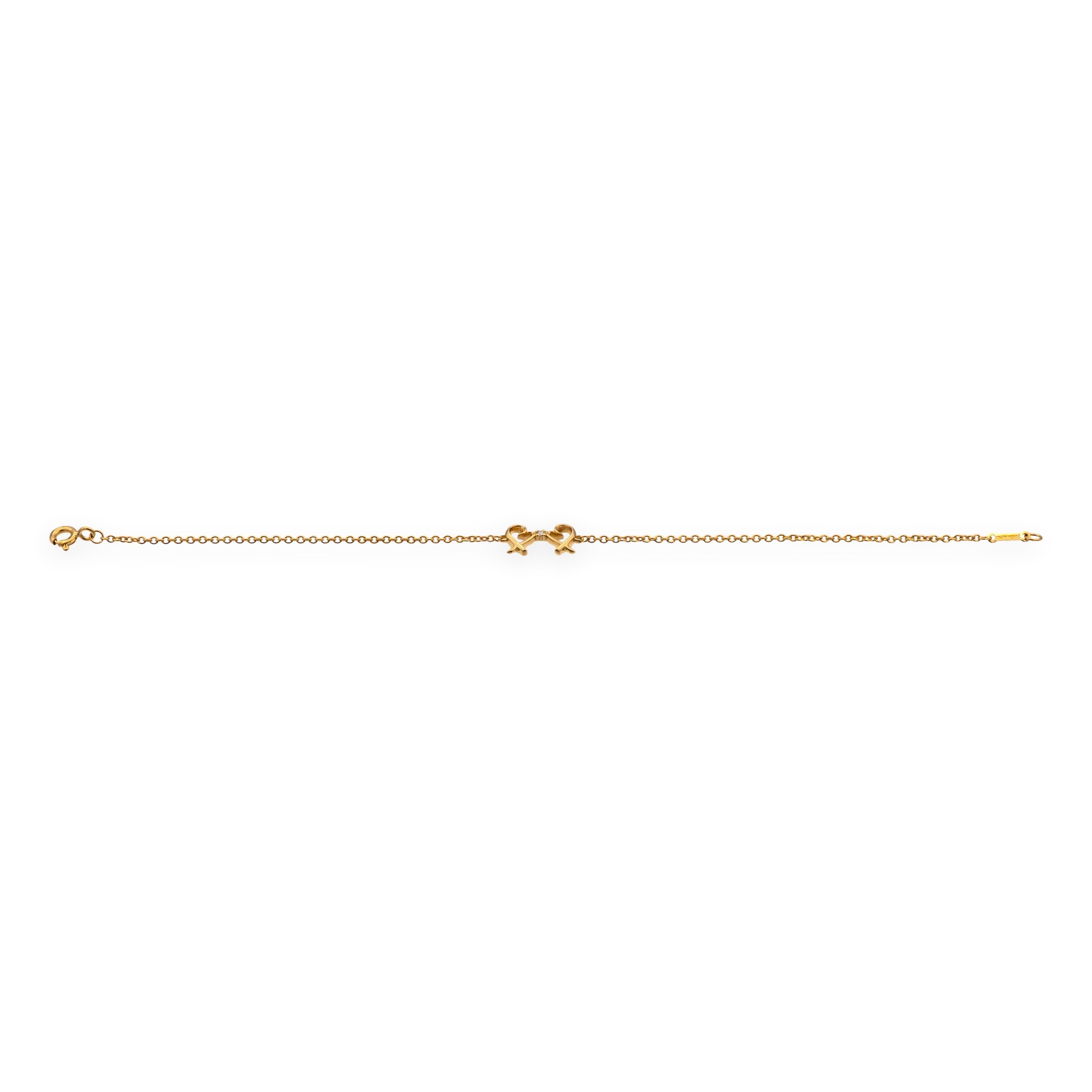 Pre-owned Tiffany & Co. “Double Loving Heart” bracelet designed by Paloma Picasso, crafted in solid 18K rose gold with a single diamond accent. The mirrored heart motif is fixed at center on a fine cable chain with spring-ring clasp; length is 7