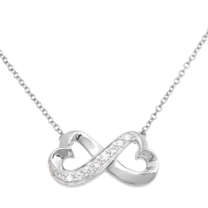 TIFFANY & Co. Paloma Picasso Collier pendentif double cœur amoureux en or blanc 18K et diamants 

Métal : Or blanc 18K
Poids : 4.20 grammes 
Chaîne : 17