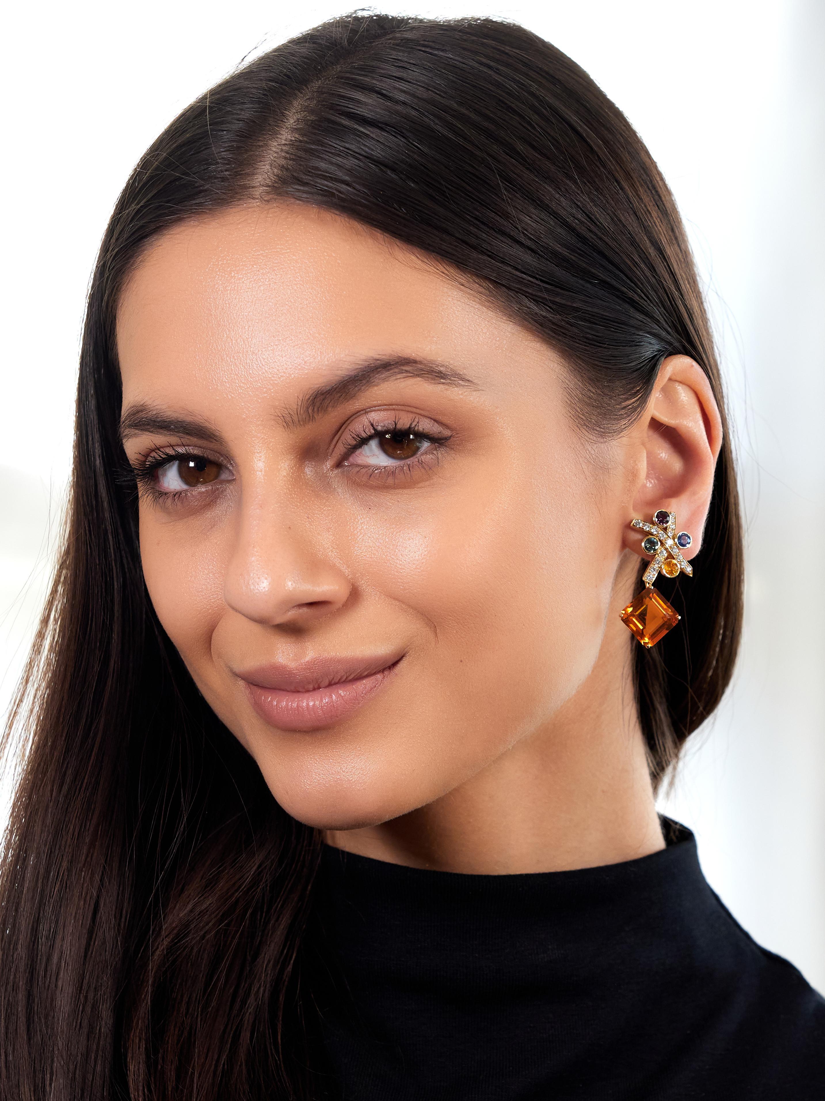 Designed as graffiti style 'X' motif forms bead set with round brilliant cut diamonds
Weighing approximately 1.20 carats total - G color with VS2 clarity
Accented by fancy colored sapphires bezel set in corners
Round cut and weighing approximately