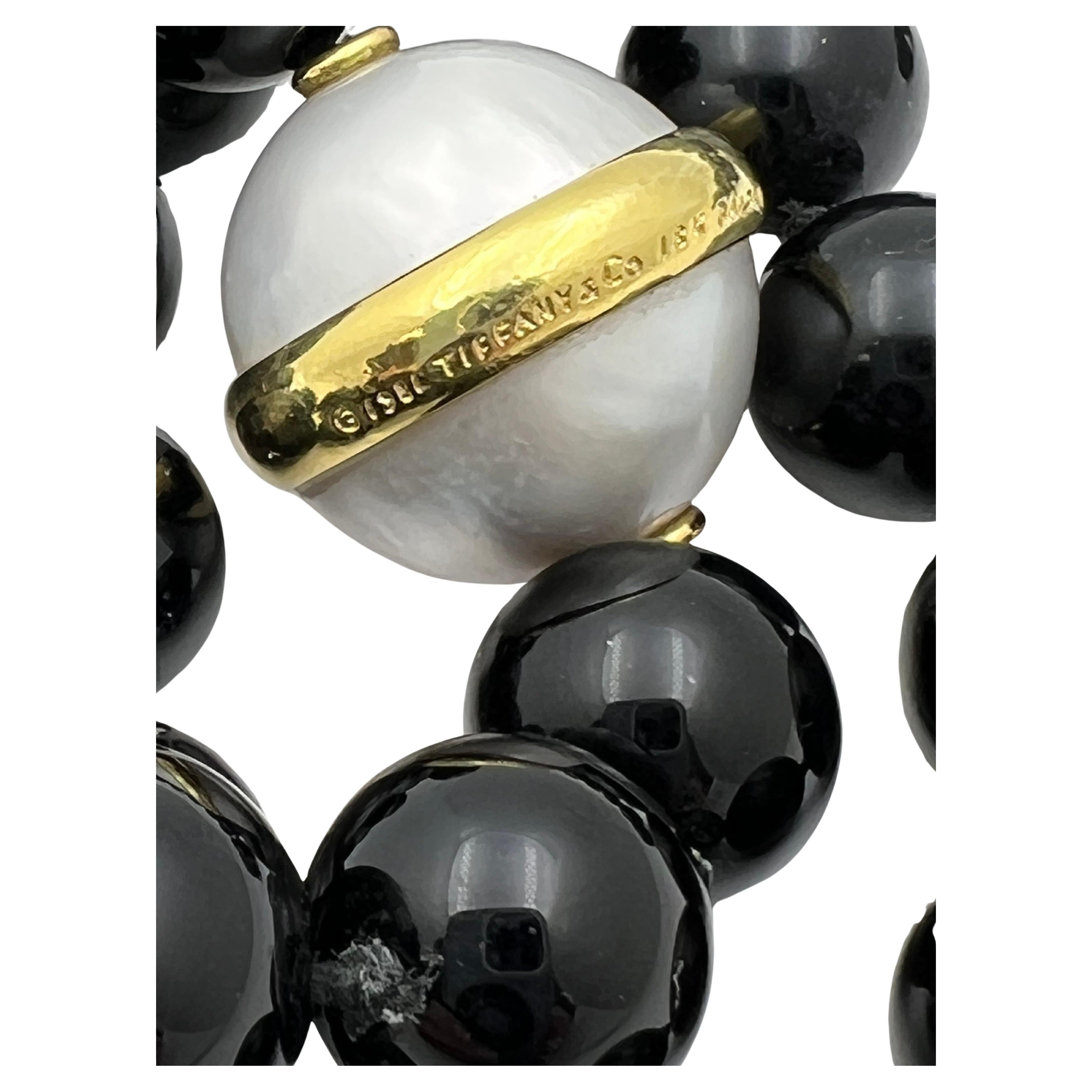 Tiffany & Co. Paloma Picasso Collana con perle dei mari del sud e onice nero. Singolo filo di sessantaquattro perle di onice nero, 12,3-12,5 mm, con una perla coltivata dei Mari del Sud di 18,5 mm accentuata da una fascia d'oro lucido intorno al
