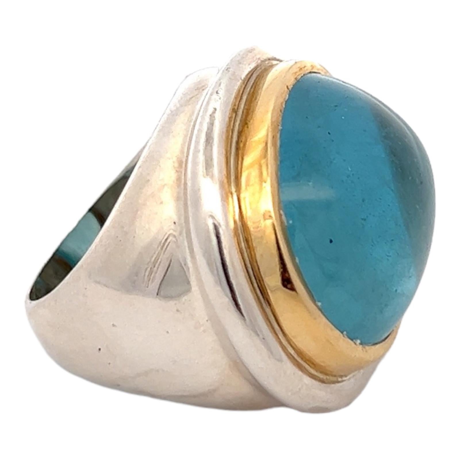 Fabulous vintage aquamarine cocktail ring by designer Paloma Picasso for Tiffany & Co. The ring features an approximately 50 carat blue aquamarine cabochon gemstone bezel set into a sterling silver and 18 karat yellow gold statement ring. The rop