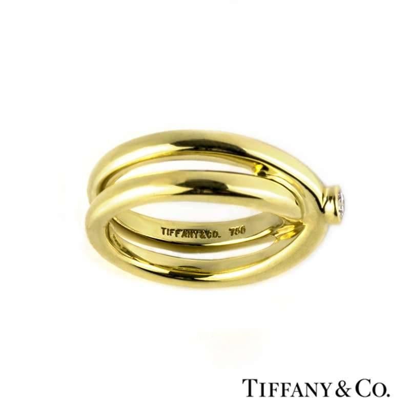 An 18k yellow gold diamond ring from the Tiffany & Co. Paloma Picasso collection. The ring is composed if a single round brilliant cut diamond weighing 0.10ct, colour G and VS clarity, set within a rub over setting. The stone is set to the centre of