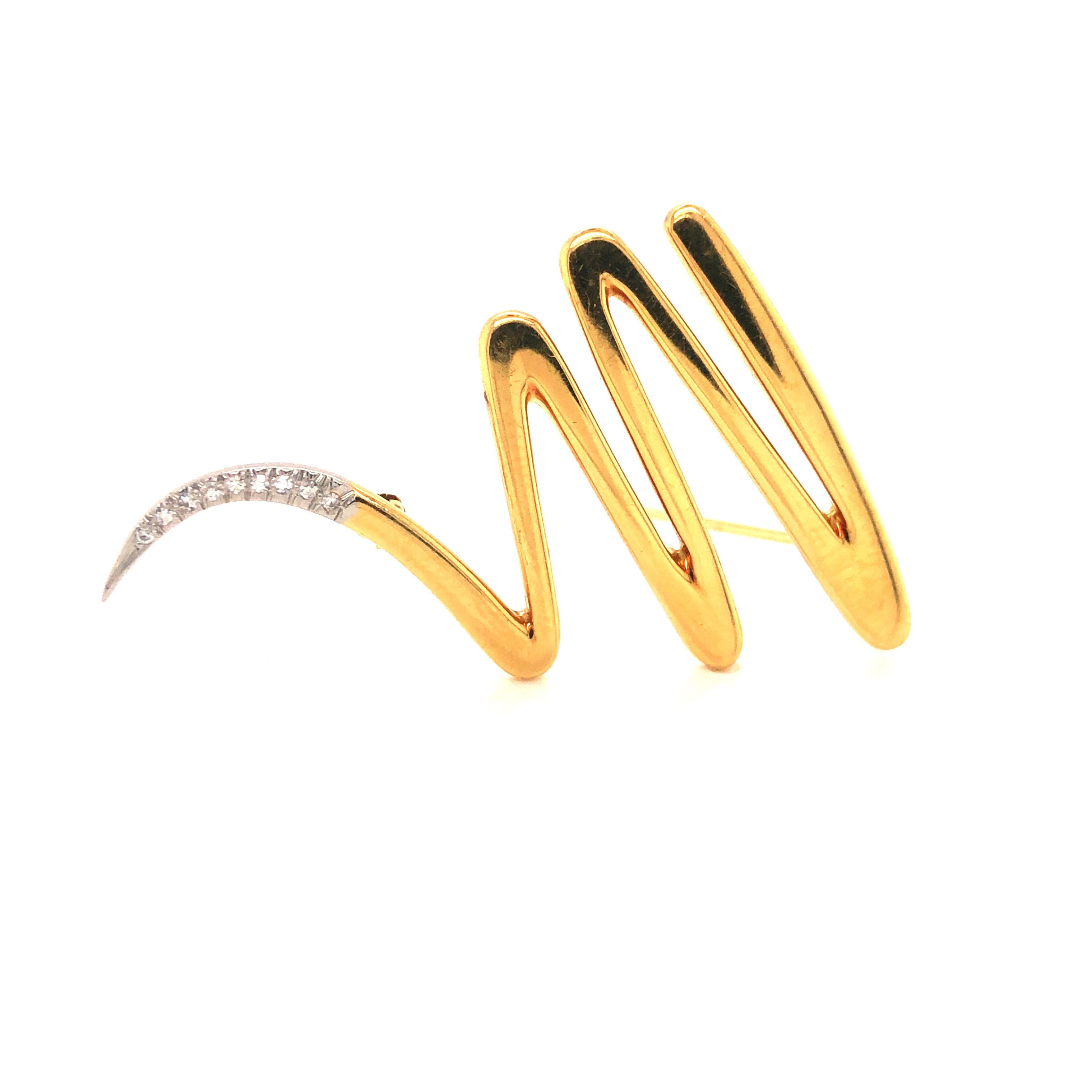 Boldly designed by Paloma Picasso for Tiffany & Co, this pin from 1983 features an abstract zig zag scribble of highly polished 18 karat yellow gold with a platinum and diamond tail. Nine round brilliant diamonds are pave set and graduate in size.
