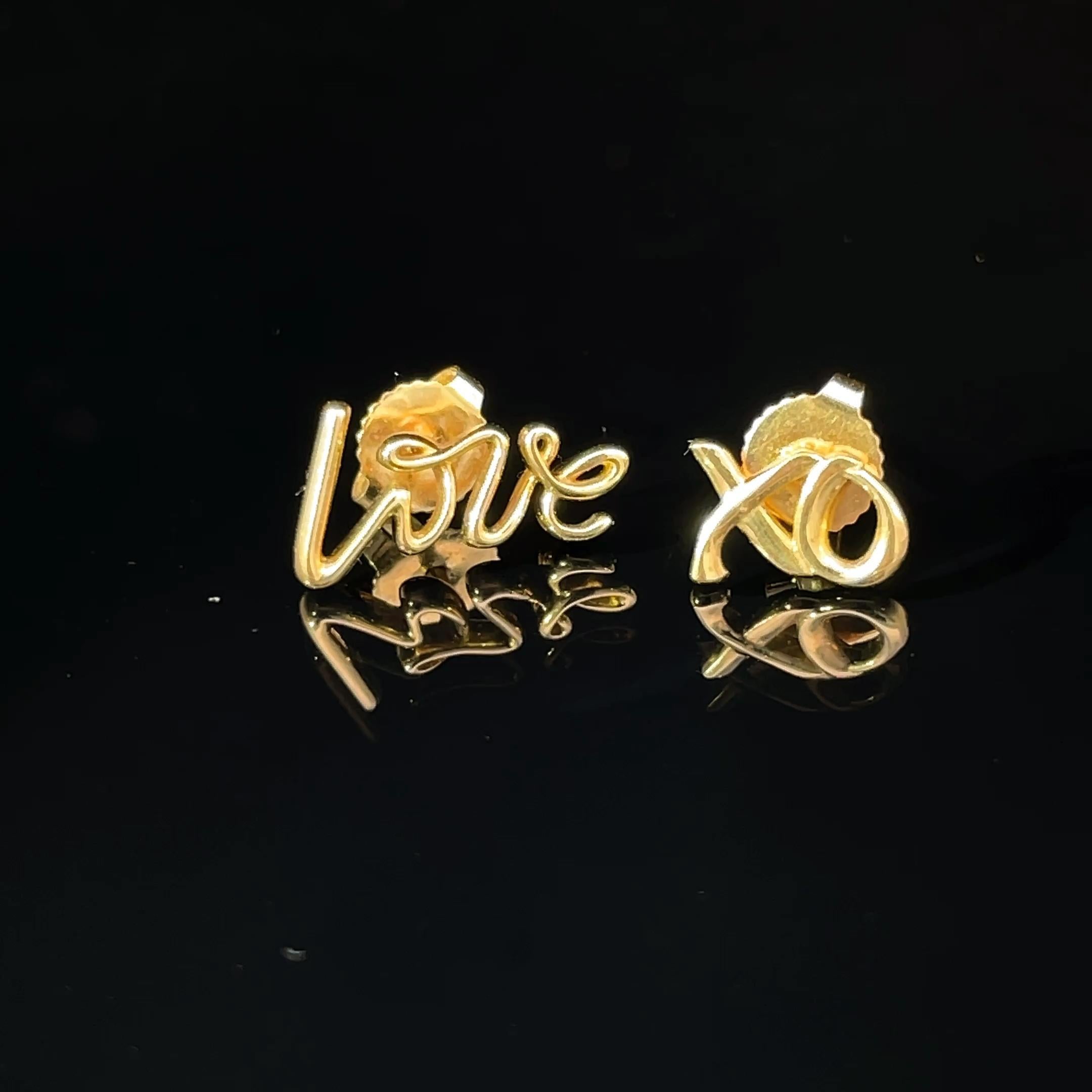 Elevate your accessory game with the exquisite Love XO Stud Earrings from Tiffany & Co., designed by the renowned Paloma Picasso. Crafted from luxurious 18k yellow gold, these earrings feature a playful yet sophisticated design that showcases the
