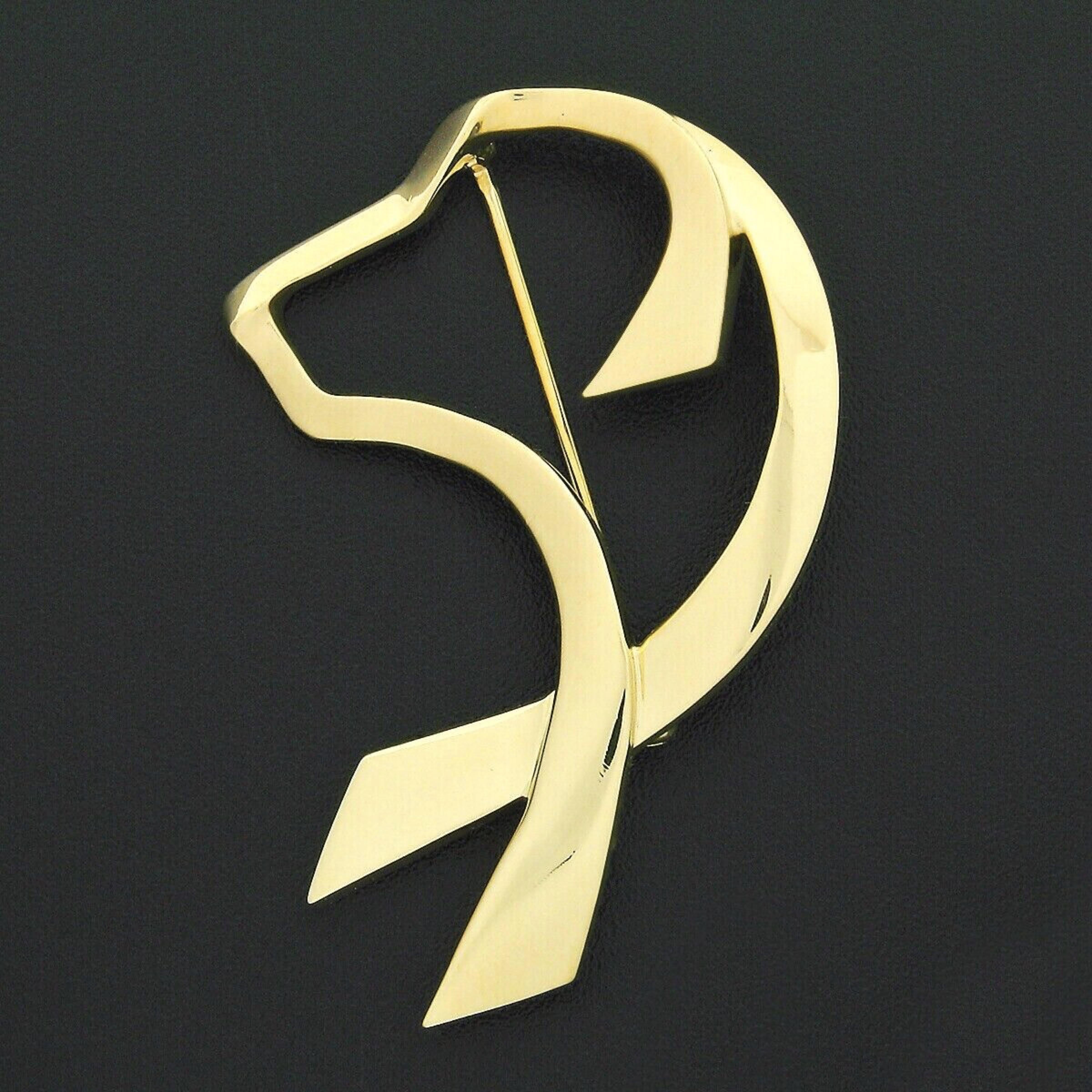 This 100% authentic Tiffany & Co. brooch was designed by Paloma Picasso and was crafted from solid 18k yellow gold. The brooch features a simple and elegant dog's head design crafted from ribbon-like sections of solid 18k yellow gold. The brooch is