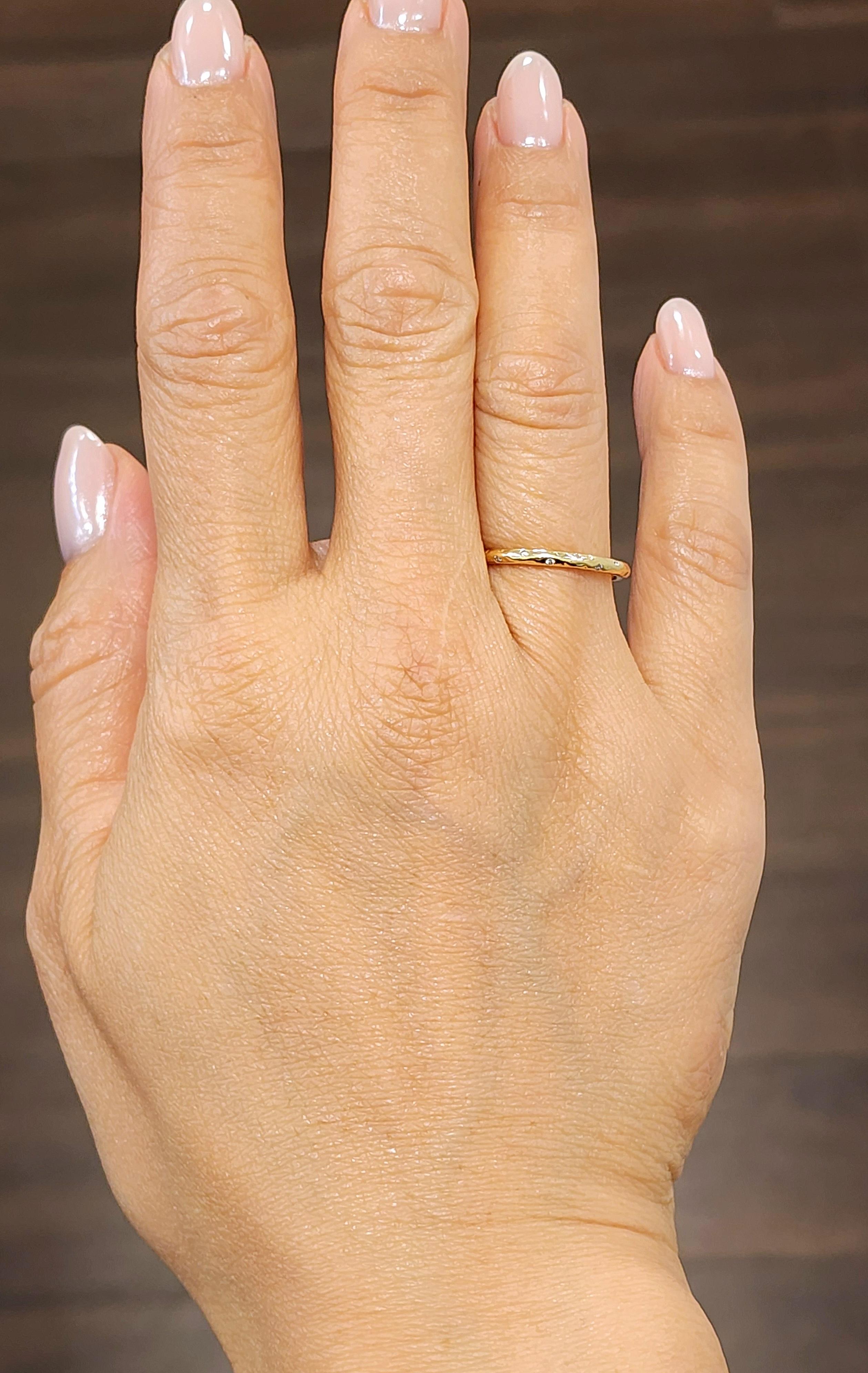 This gorgeous band ring by Tiffany & Co. features a delicate array of round white diamonds, totaling approximately 0.3 carats. The diamonds are F/G in color and VVS1 in clarity, set in luxurious 18k yellow gold. Crafted in the United States, this