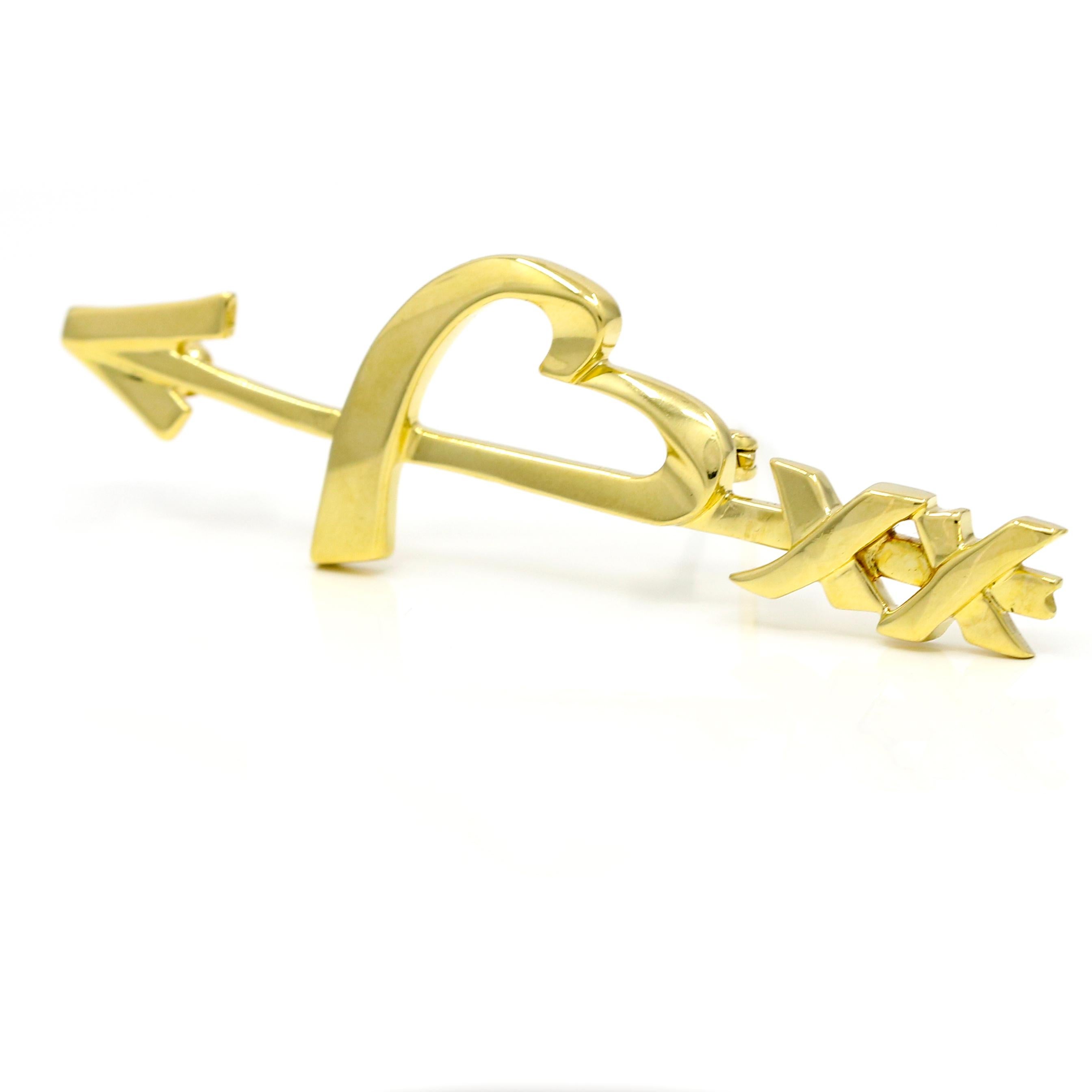 Heart and arrow brooch in 18-karat yellow gold by Paloma Picasso for Tiffany & Co. 

Length, 54mm
Width, 16mm
Depth, 2.5mm 
Weight, 6.1 grams 

Previously owned, in excellent condition. Original packaging not included. Cleaned and polished. All