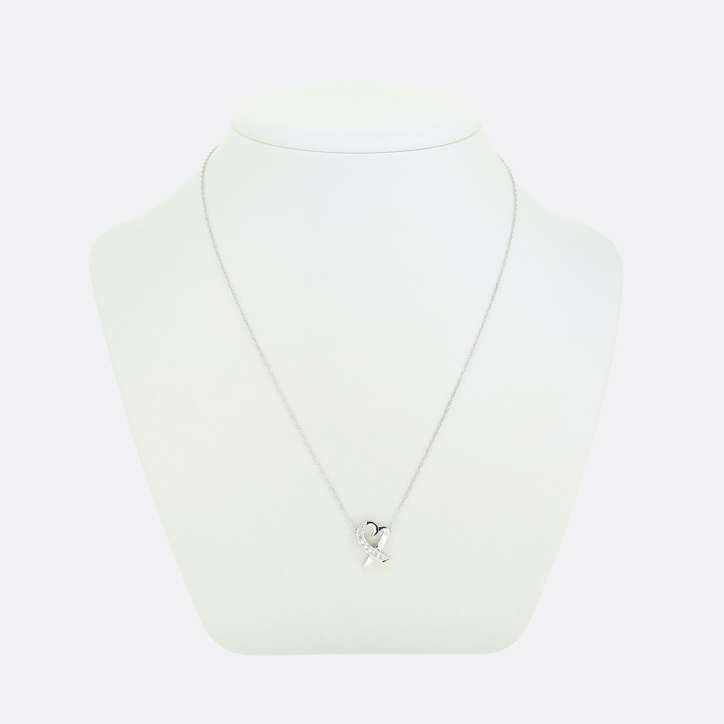 Ecco una romantica collana di Tiffany & Co., gioielliere di fama mondiale. Il ciondolo presenta un grazioso design a cuore aperto, parzialmente ornato da diamanti bianchi rotondi a taglio brillante che ne esaltano lo scintillio e il fascino.