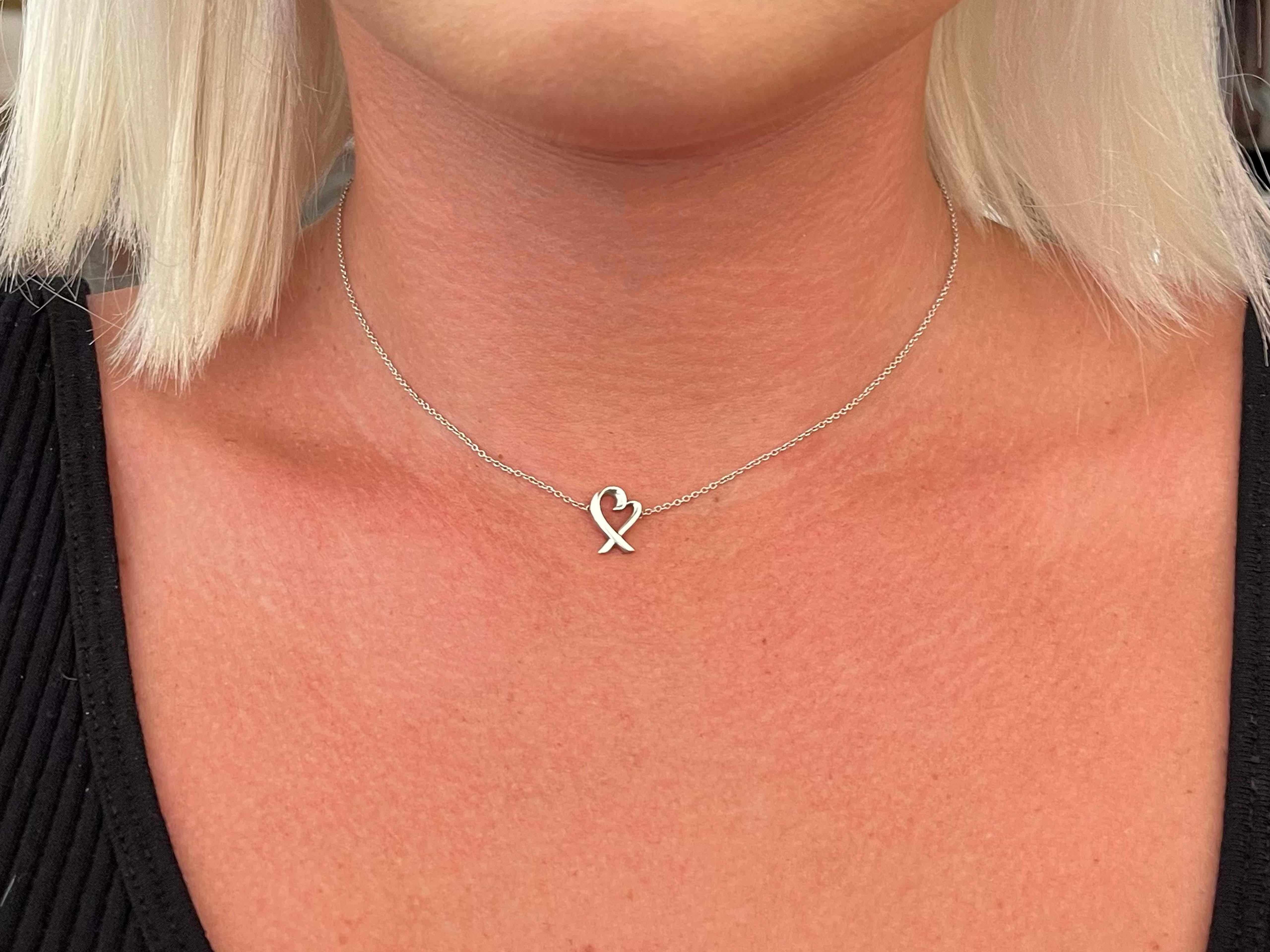 This is an authentic TIFFANY Sterling Loving Heart Pendant Necklace. The necklace is crafted of sterling silver and features heart pendant on a silver chain. The pendant measures 11.56 mm x 8.77 mm and comes on a 16 inch Tiffany & Co. link chain.
