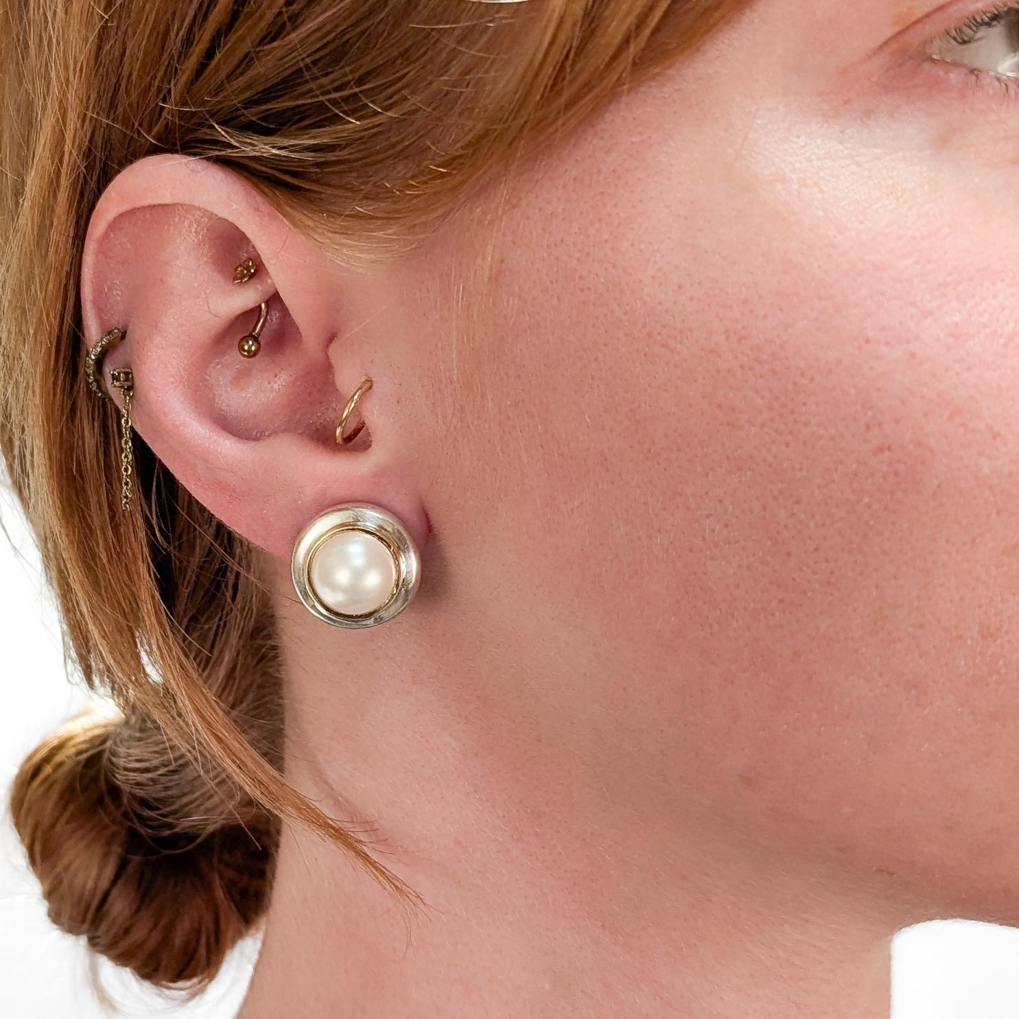Un bel paio di orecchini a clip firmati.

Di Paloma Picasso for Tiffany & Co.

In argento sterling.

Con perle mabe bianche incastonate in un castone d'oro 18 carati su ogni centro.

Assicurati con chiusure a clip.

Completamente marcato sul