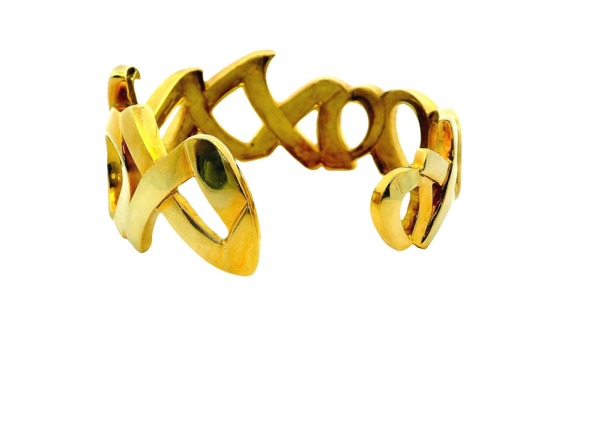 Eleva tu estilo con esta impresionante pulsera Paloma Picasso Love & Kisses de oro amarillo de 18 quilates. Paloma Picasso entró a formar parte de Tiffany & Co. en 1980, y su vibrante uso del color y sus innovadores diseños cautivaron rápidamente al