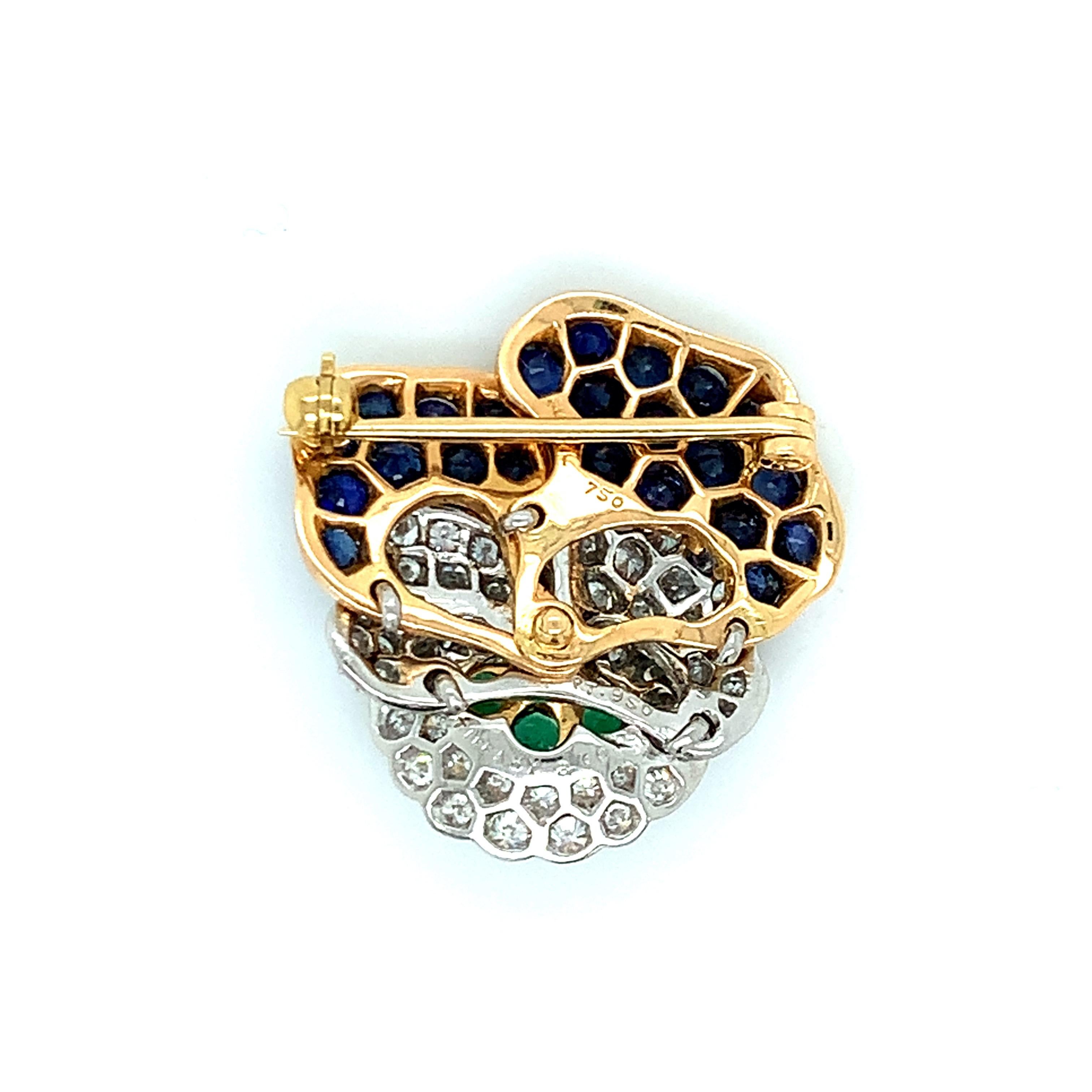 Broche emblématique en forme de fleur de pensée de Tiffany & Co, sertie d'or 18k et de platine, mettant en valeur des émeraudes, des saphirs bleus et environ 1,00ctw de diamants G/VS. La broche mesure 1