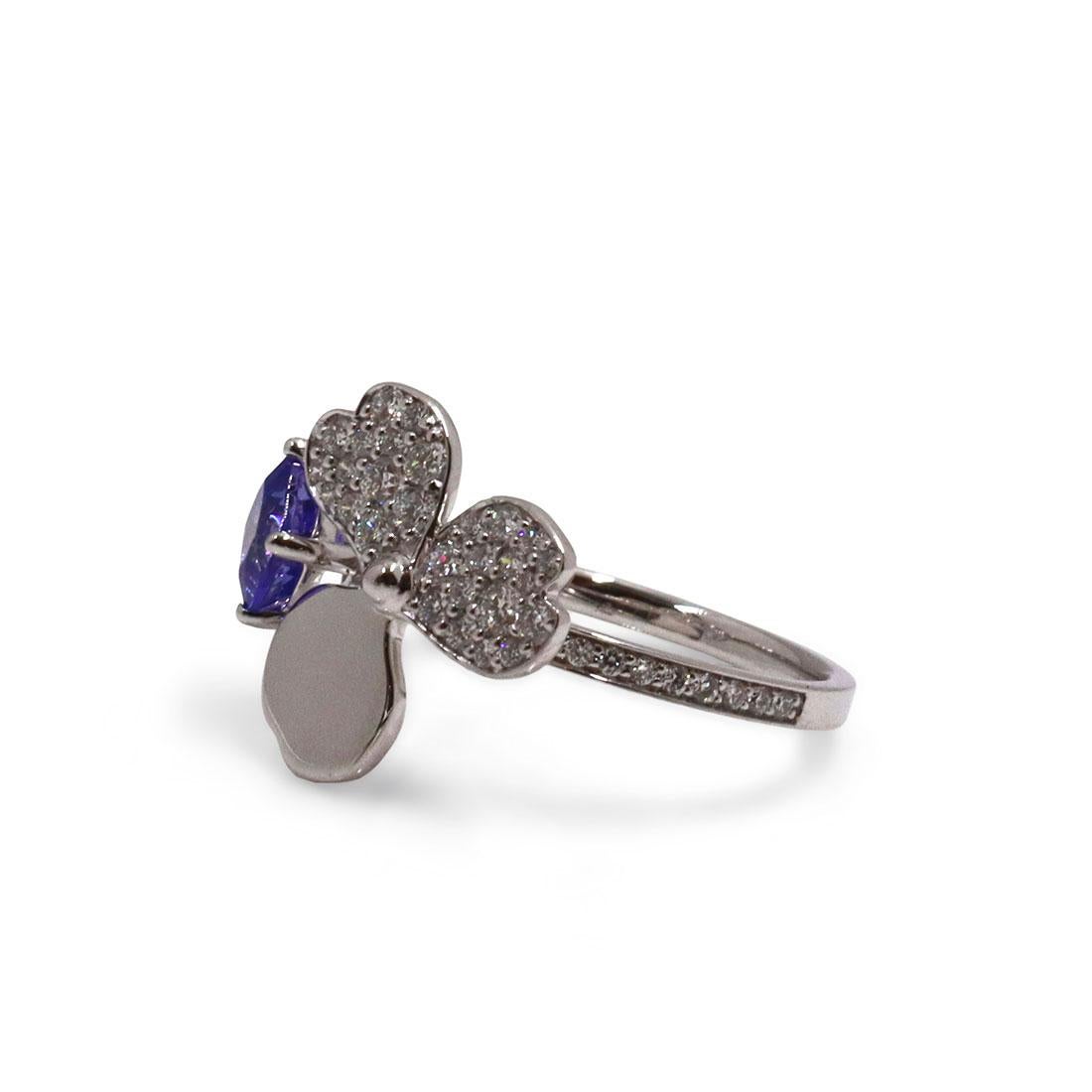 Authentic Tiffany & Co. 'Paper Flowers' ring crafted in platinum. This stunning ring features a floral-shaped setting with an estimated .30 carats of round diamonds and a faceted square tanzanite. Size 6. 
Signed Tiffany & Co., PT950. The ring is