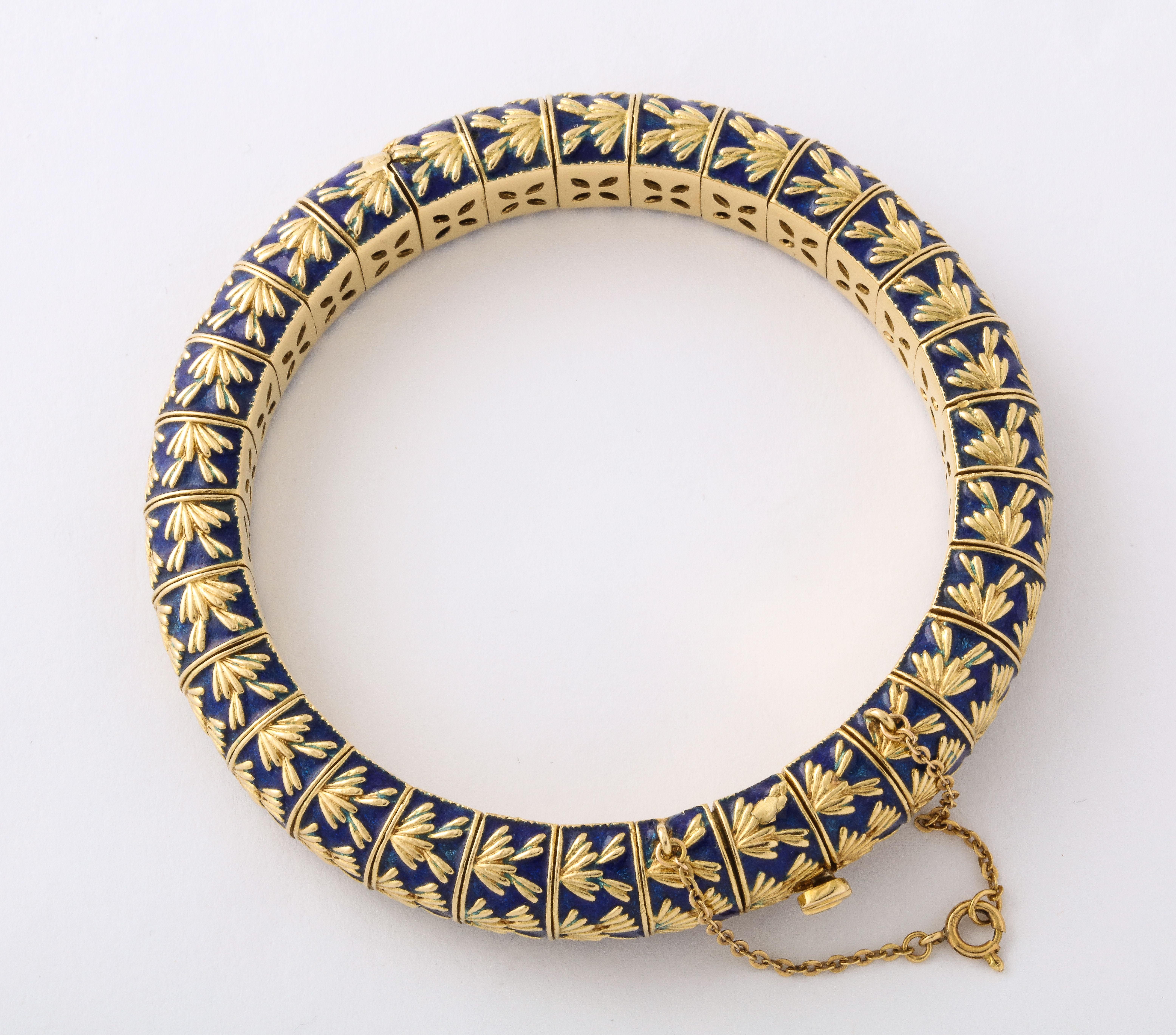 We offer a perfectly elegant 1960s Tiffany & Co. - Paris bangle bracelet of 18K gold segments with rich blue enameled details with a slight flexibility and hinged for easy on and off with a safety latch and safety chain. Wear it stacked or
