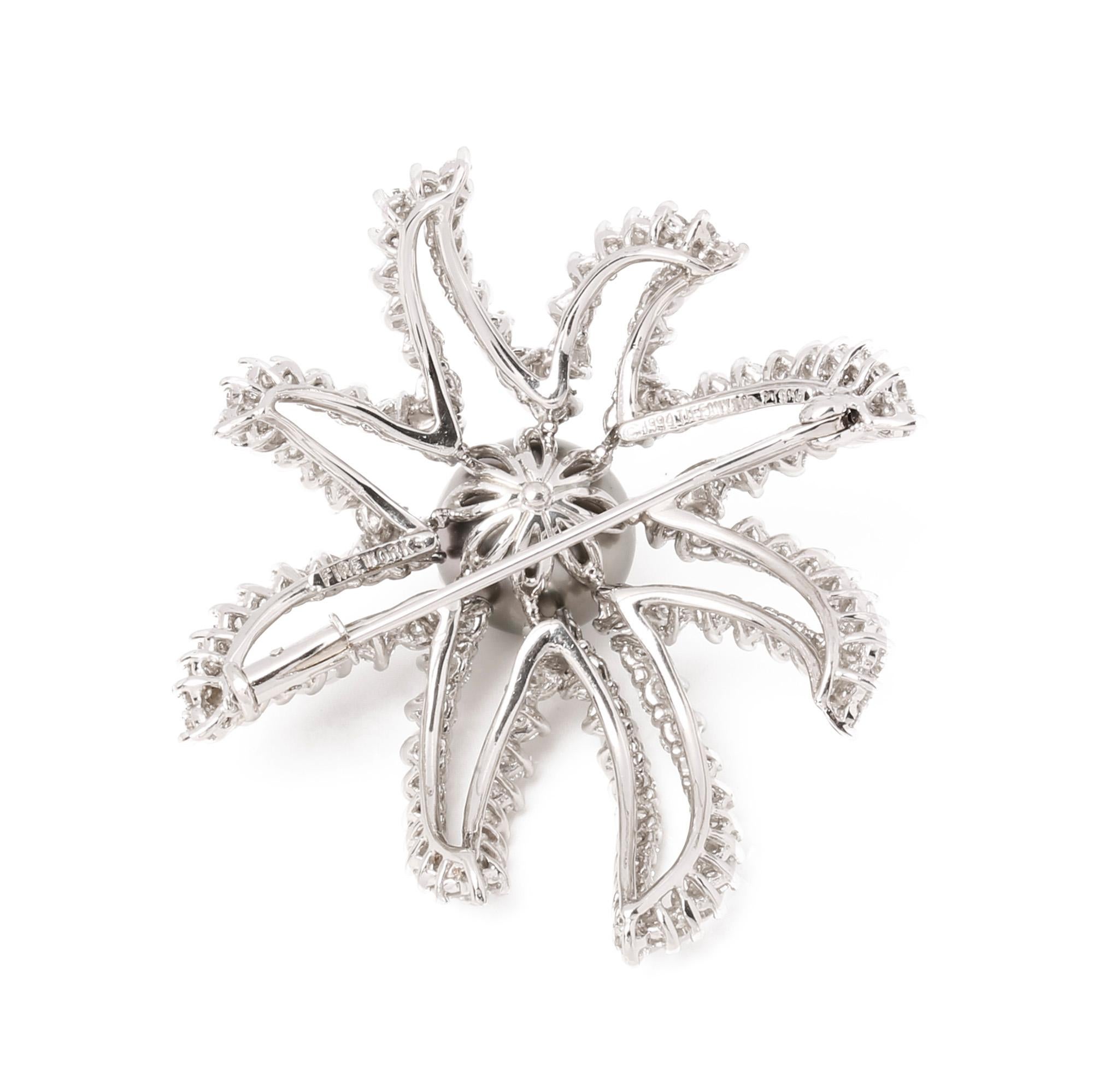 This 1994 Brooch by Tiffany & Co. features a pearl and diamond firework design, made in platinum and featuring round cut diamonds totalling 3.0-3.5 carats around a central pearl of 11mm. 