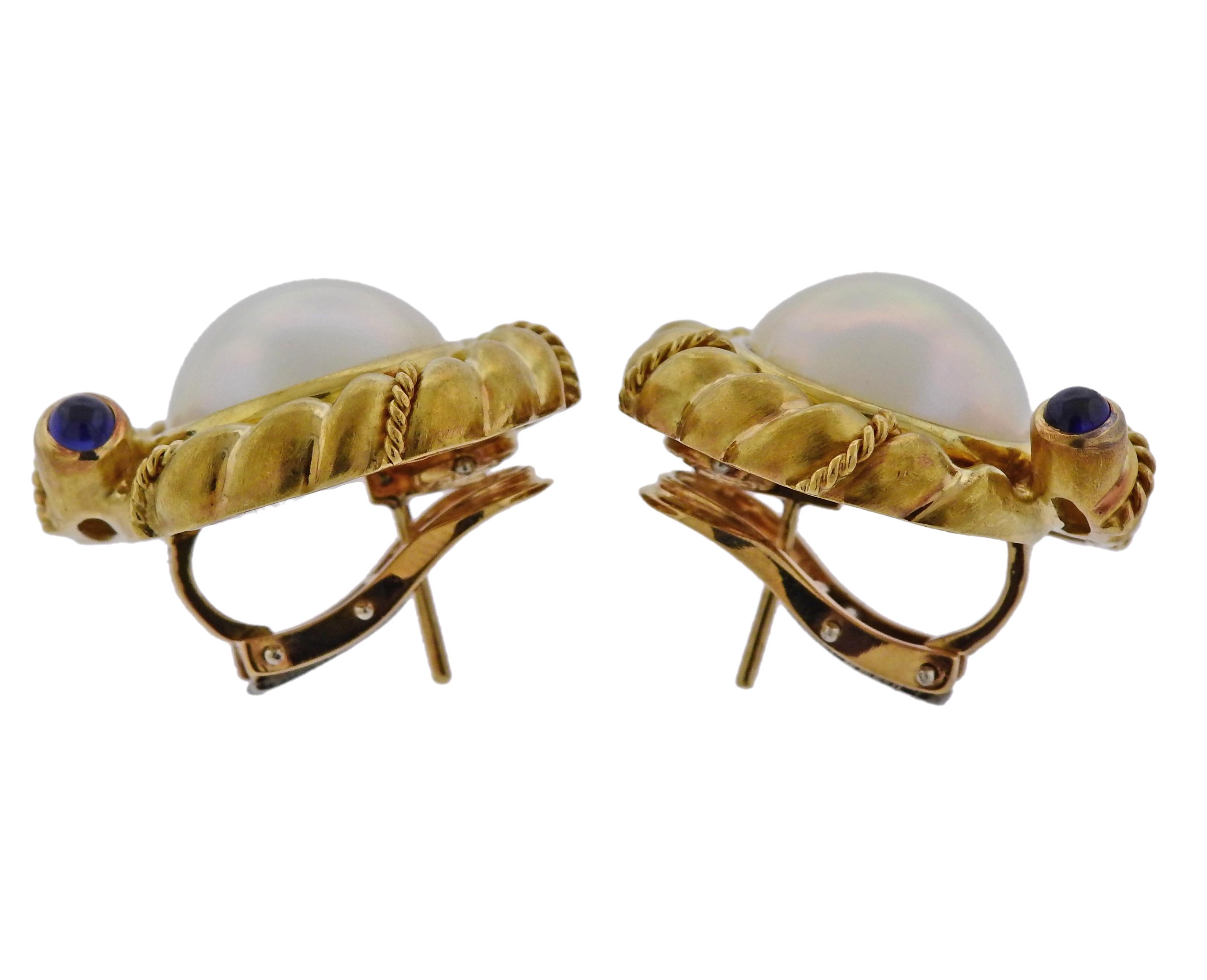Pair of 18k yellow gold earrings, crafted by Tiffany & Co, set with 14.4mm mabe pearls, and sapphire cabochons. Earrings are 23mm in diameter  and weigh 29.4 grams. Marked Tiffany & Co, Italy, 750. 