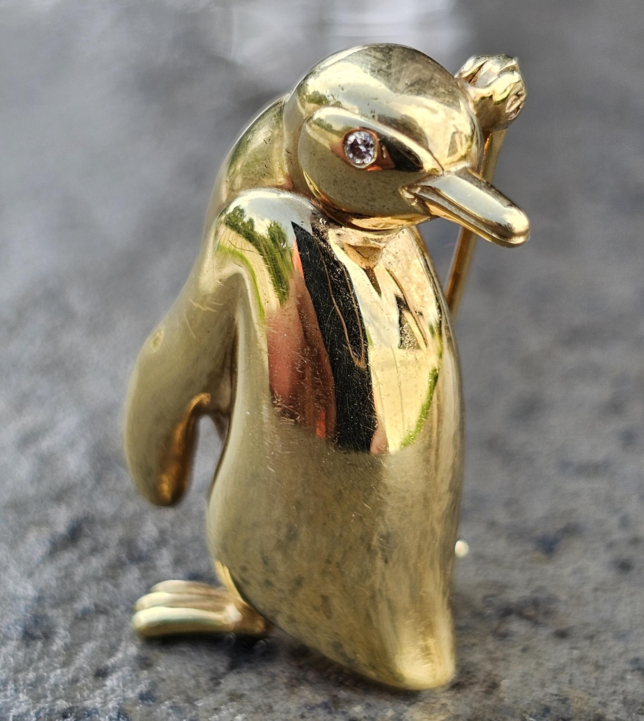 Eleva tu estilo con esta exquisita joya de Tiffany & Co. Broche Pingüino. Fabricada en oro amarillo de 18 quilates, esta encantadora pieza presenta un acabado pulido y elegante. El ojo del pingüino está adornado con un diamante blanco, que añade un