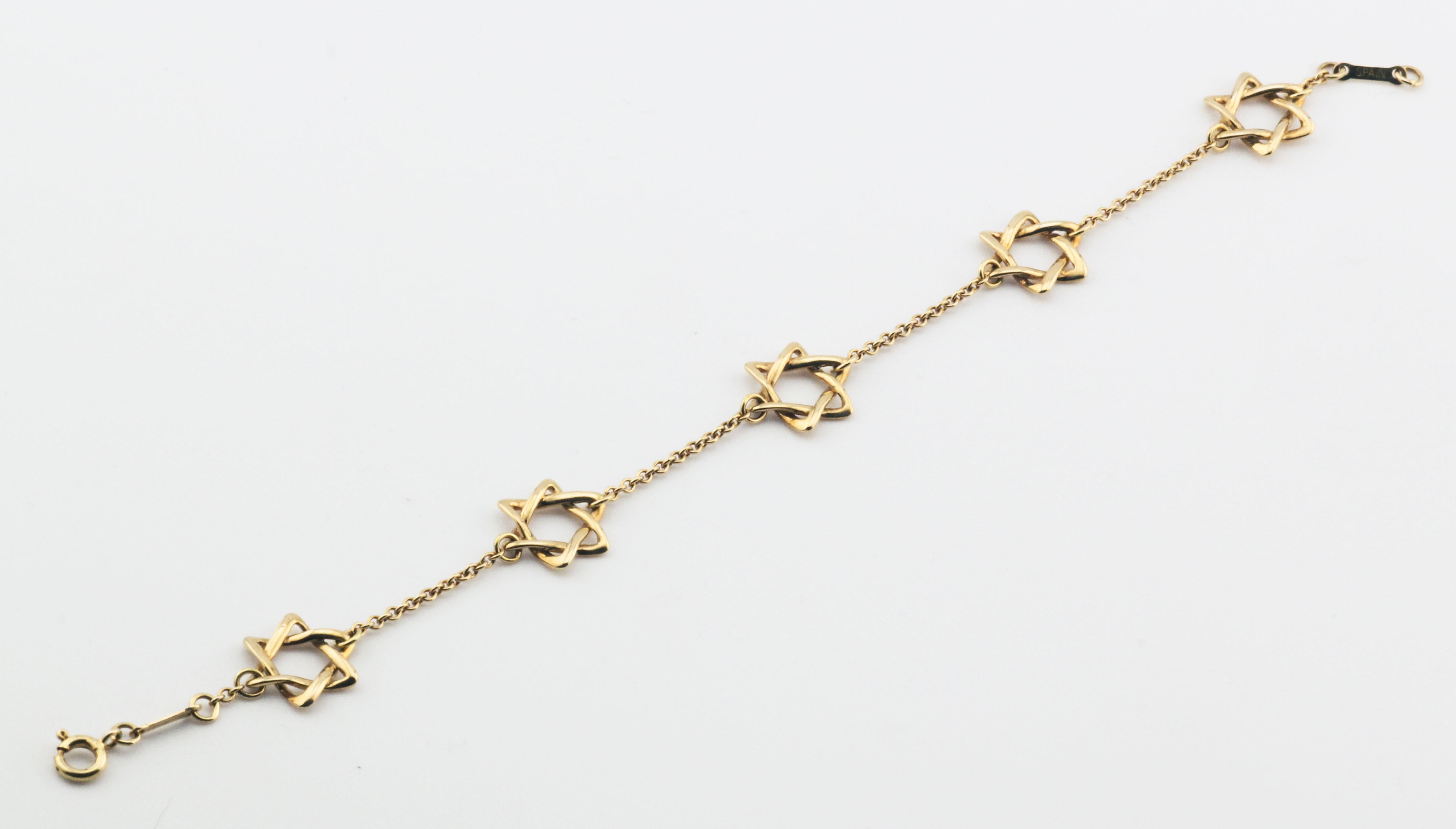 The Tiffany & Co. Elsa Peretti 18K Yellow Gold Star of David Bracelet is a stunning expression of both elegance and personal meaning. Designed by the iconic Elsa Peretti, this bracelet features five delicately crafted Star of David designs, each