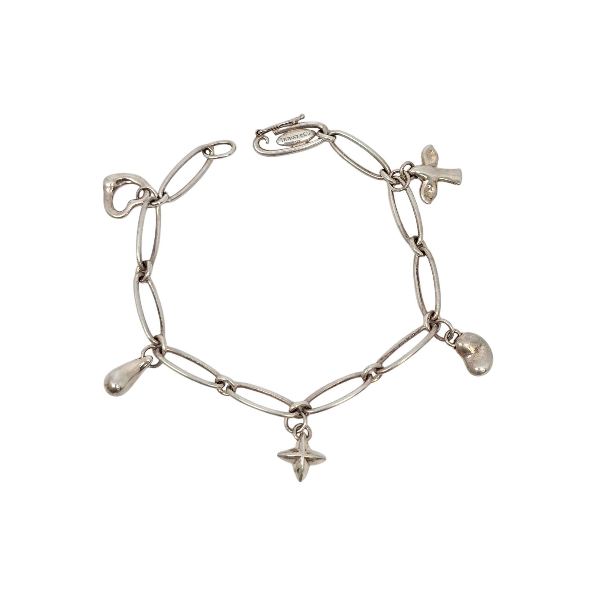 Sterling silver charm bracelet by Elsa Peretti for Tiffany & Co.

A paper clip style bracelet featuring 5 iconic Elsa Peretti design dangling charms: open heart, teardrop, cross star, bean and dove. Tiffany & Co box and pouch are not