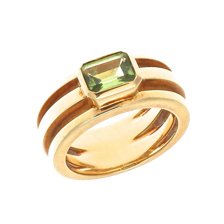 Exuberant style in dashing fashion, pure Tiffany. Featuring a glowing green peridot surrounded by contours of impeccably aligned 18k yellow gold. Signed Tiffany & Co.