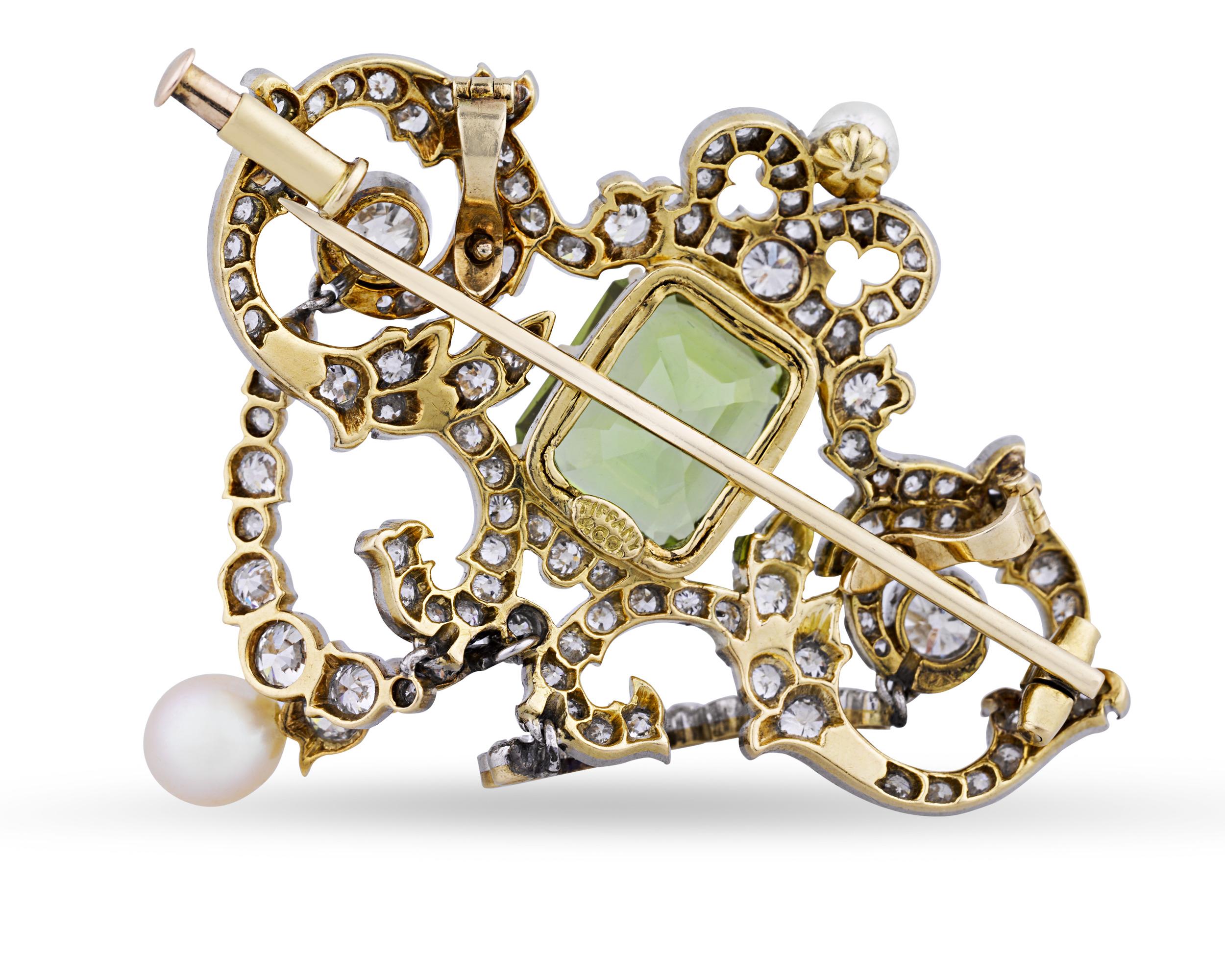 This early 20th-century pendant by Tiffany & Co. features a mesmerizing emerald-cut peridot weighing 5.50 carats embellished with 120 Old European-cut diamonds totaling 3.75 carats. The elegant pendant also features two lustrous pearls set in 18K