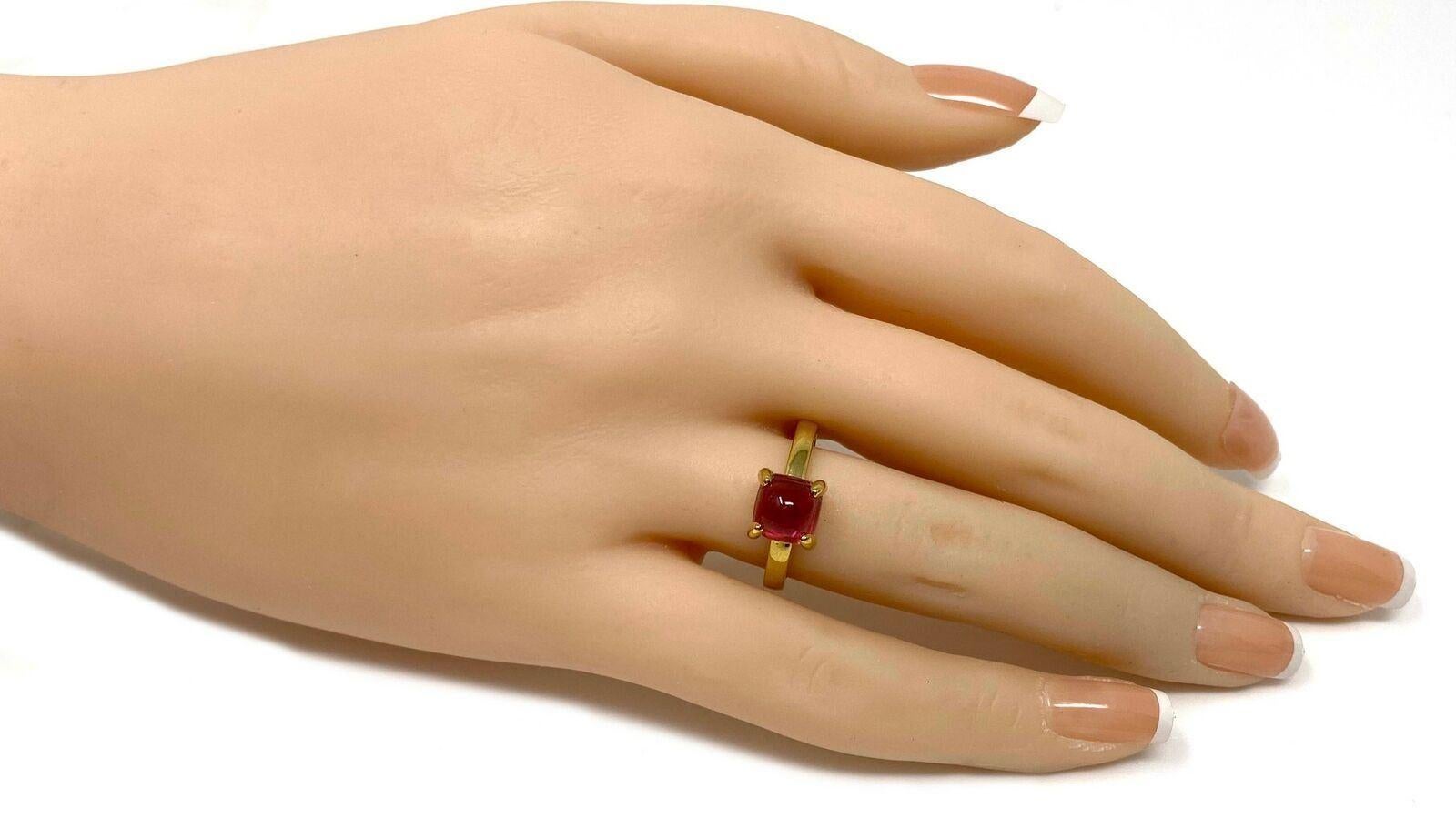 This is a lovely authentic solitaire stone ring from Tiffany & Co. by designer Paloma Picasso from her Sugar Stacks collection. It is crafted from 18k yellow gold with a polished finish featuring a cabochon rubellite gemstone mounted in four sturdy