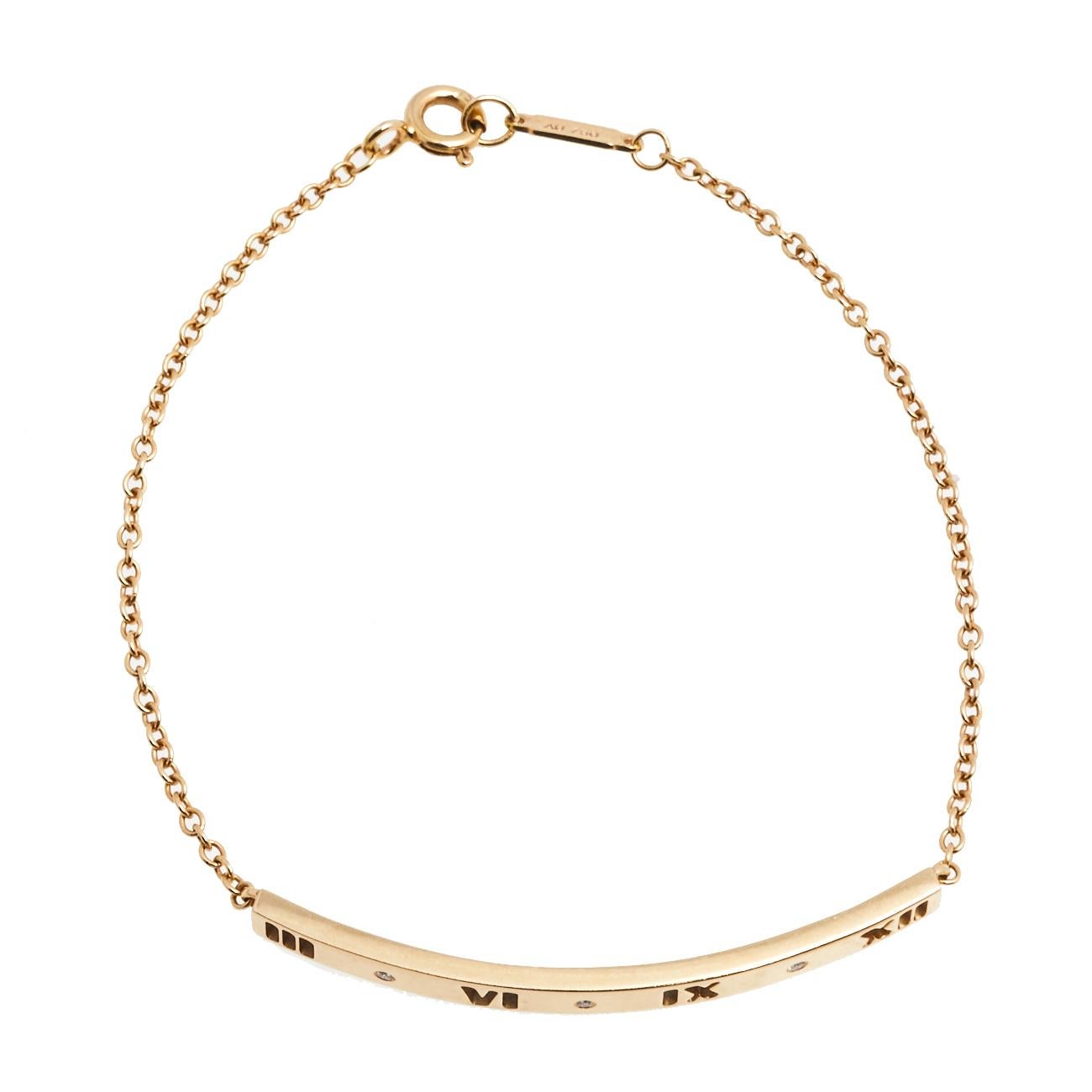 Gift your loved one this delicate-looking Tiffany & Co. Atlas bracelet. Made from 18K yellow gold, it features diamonds on the front plaque along with signature cutout Roman numerals. It is held by a chainlink and has a spring lock closure.


