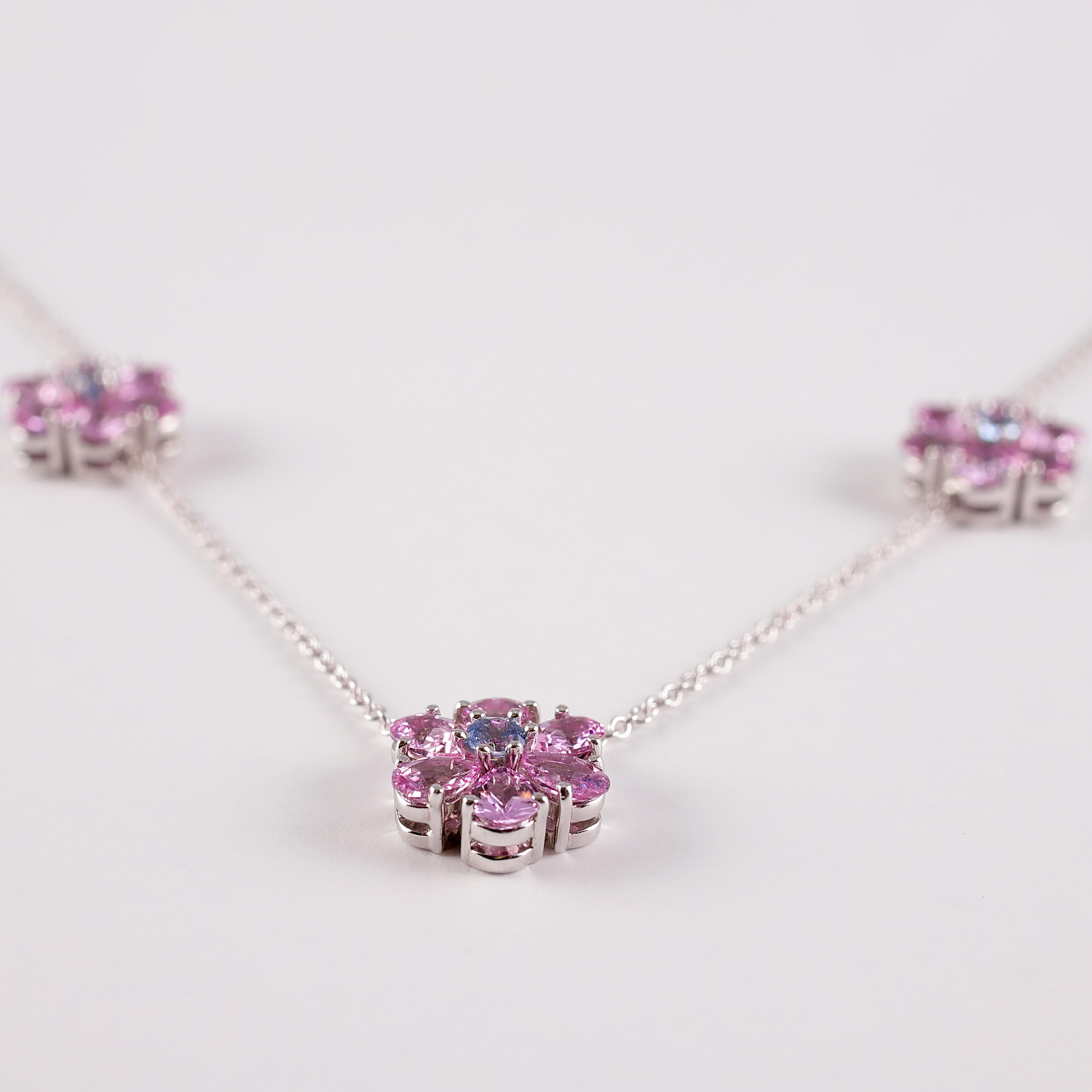 A fun and flirty look for any age!! This platinum, interlocking link necklace is secured with a spring ring clasp and suspends flower three stations that support a total of 3.00 carats pink sapphires and 0.15 carats blue sapphires .  