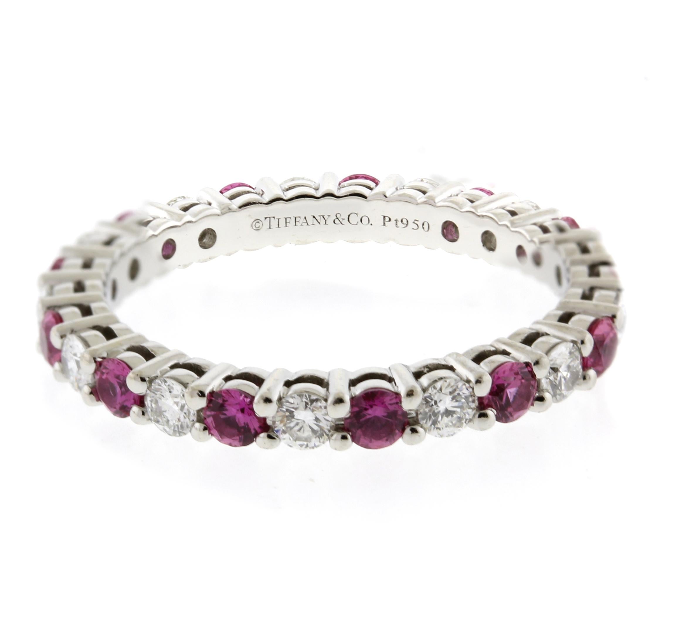 From Tiffany  & Co.'s Embrace collection; a band ring with a full circle of round brilliant diamonds and pink sapphires, set in in platinum.  
♦ Designer: Tiffany & Co.
♦ Metal: Platinum
♦ Circa 2015
♦ Size 4½
♦ 2.2mm wide 
♦ 13 diamond =.42, 13