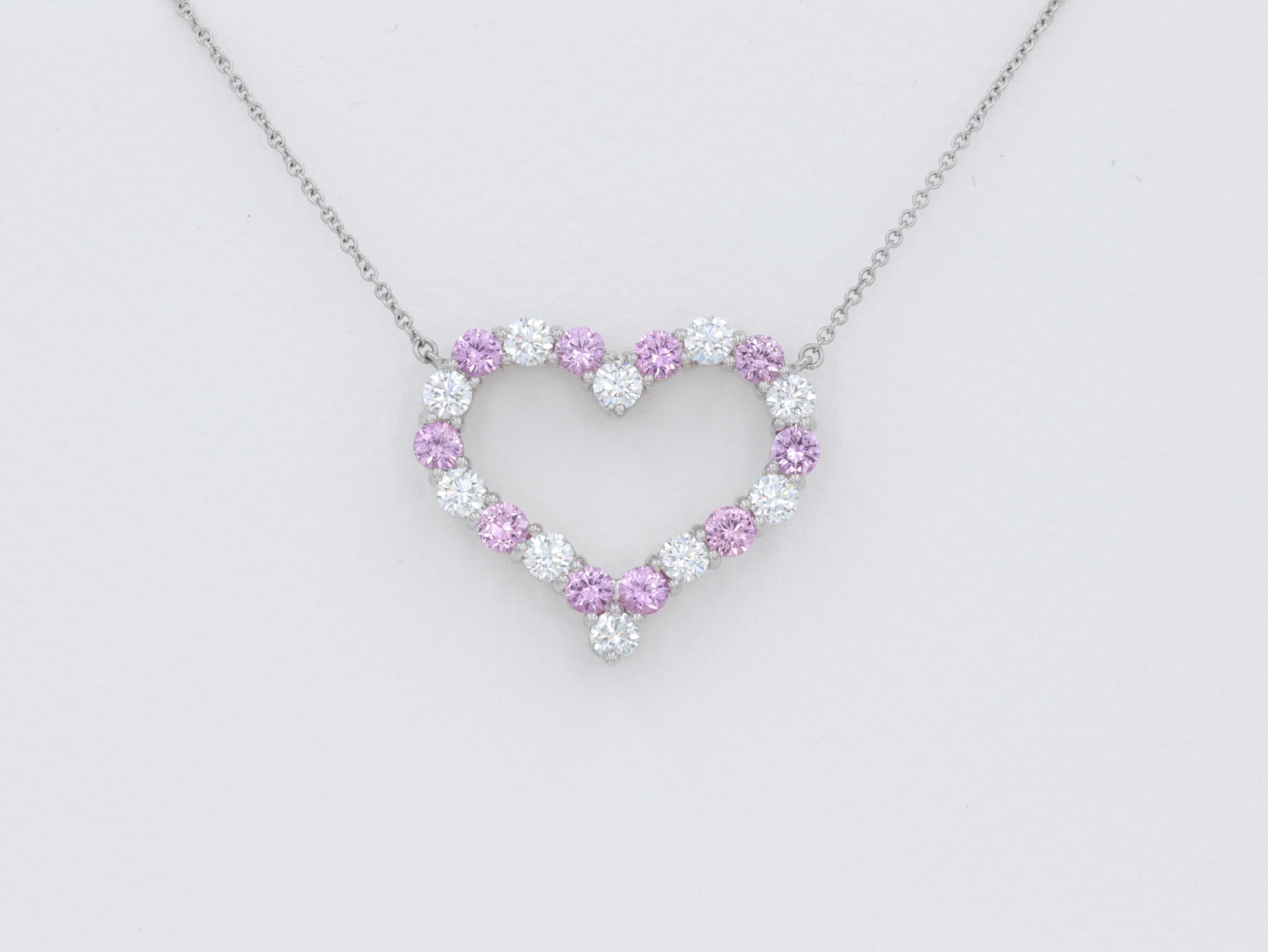 Large Tiffany & Co. Pink Sapphire and Diamond Heart Pendant Necklace featuring fine cut round brilliant diamonds and round cut pink sapphires set in platinum. 

The diamonds weigh approximately 1 carat in total and are of fine quality with colors of
