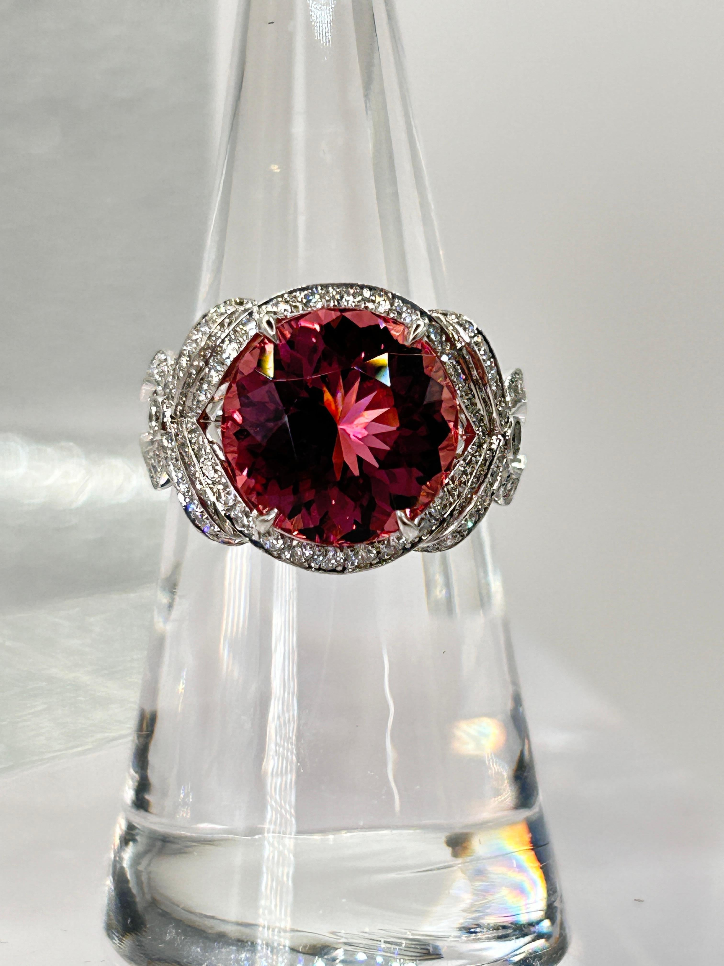 Rare, Beautiful and Unique Tiffany & Co. Platinum Ring Set with a Round Pink Tourmaline weighing 5.34 Carats.  The Tourmaline is Surrounded by Round Brilliant Cut Diamonds in a Bow Motif Design.
Stamped inside the shank: Tiffany & Co. PT950