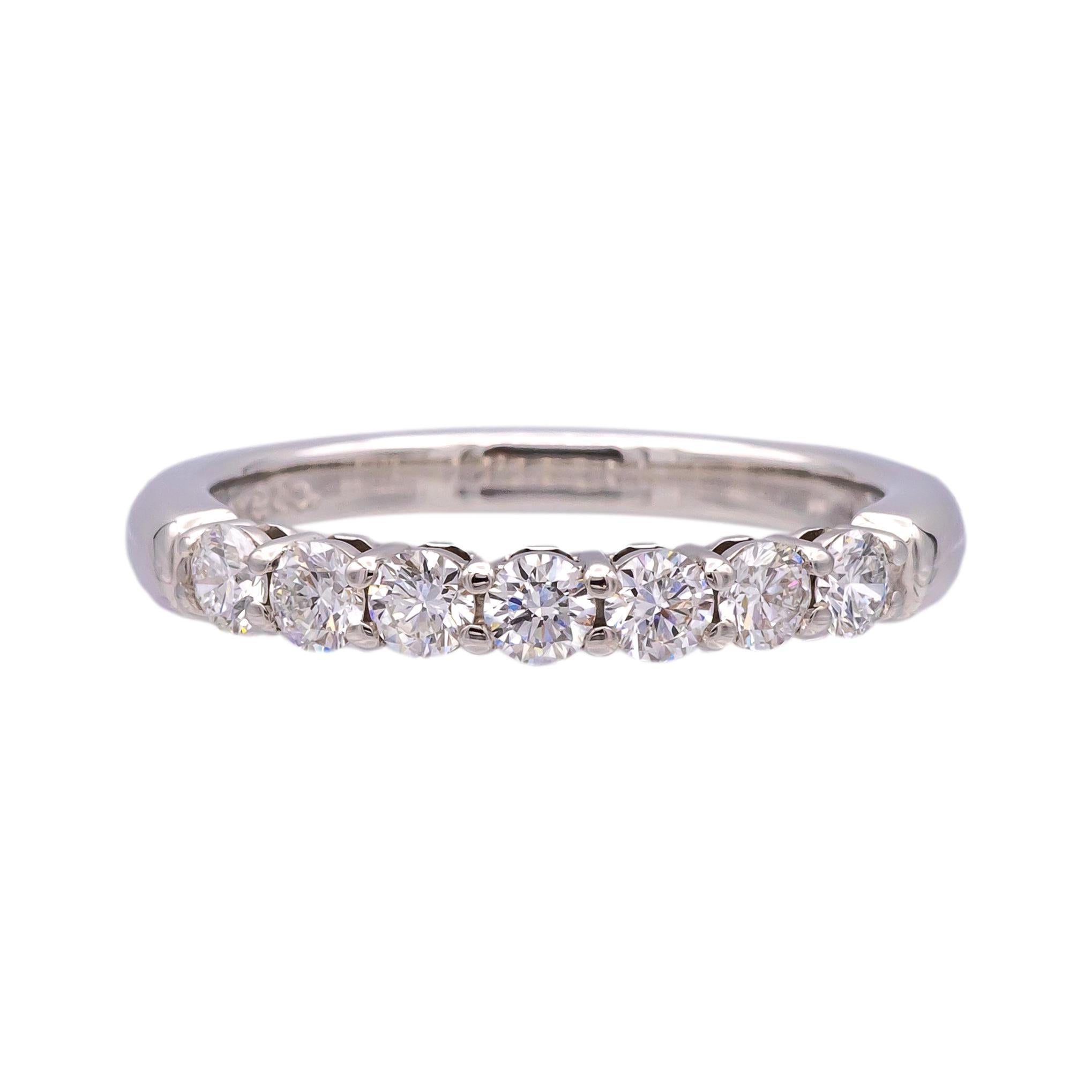This Tiffany & Co. Forever Half Circle Band Ring is made from platinum and set with seven round brilliant-cut diamonds totaling 0.57 carats. The diamonds are D-G color and VS2 clarity, offering excellent quality. The band measures 2.2 mm in width