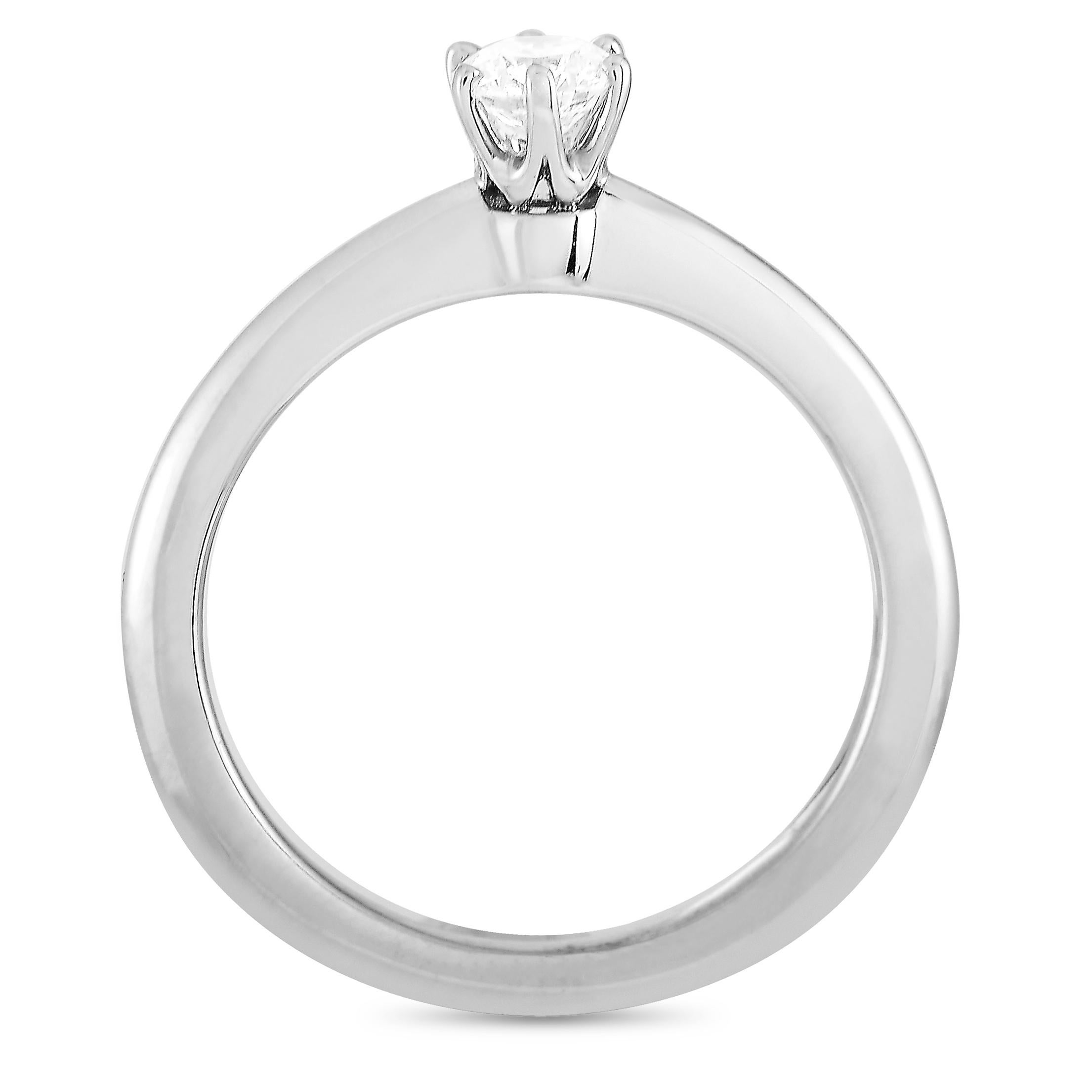 This Tiffany & Co. engagement ring is crafted from platinum and set with a 0.26 ct diamond stone that features E color and VVS2 clarity. The ring weighs 4 grams and boasts band thickness of 2 mm and top height of 6 mm, while top dimensions measure 5