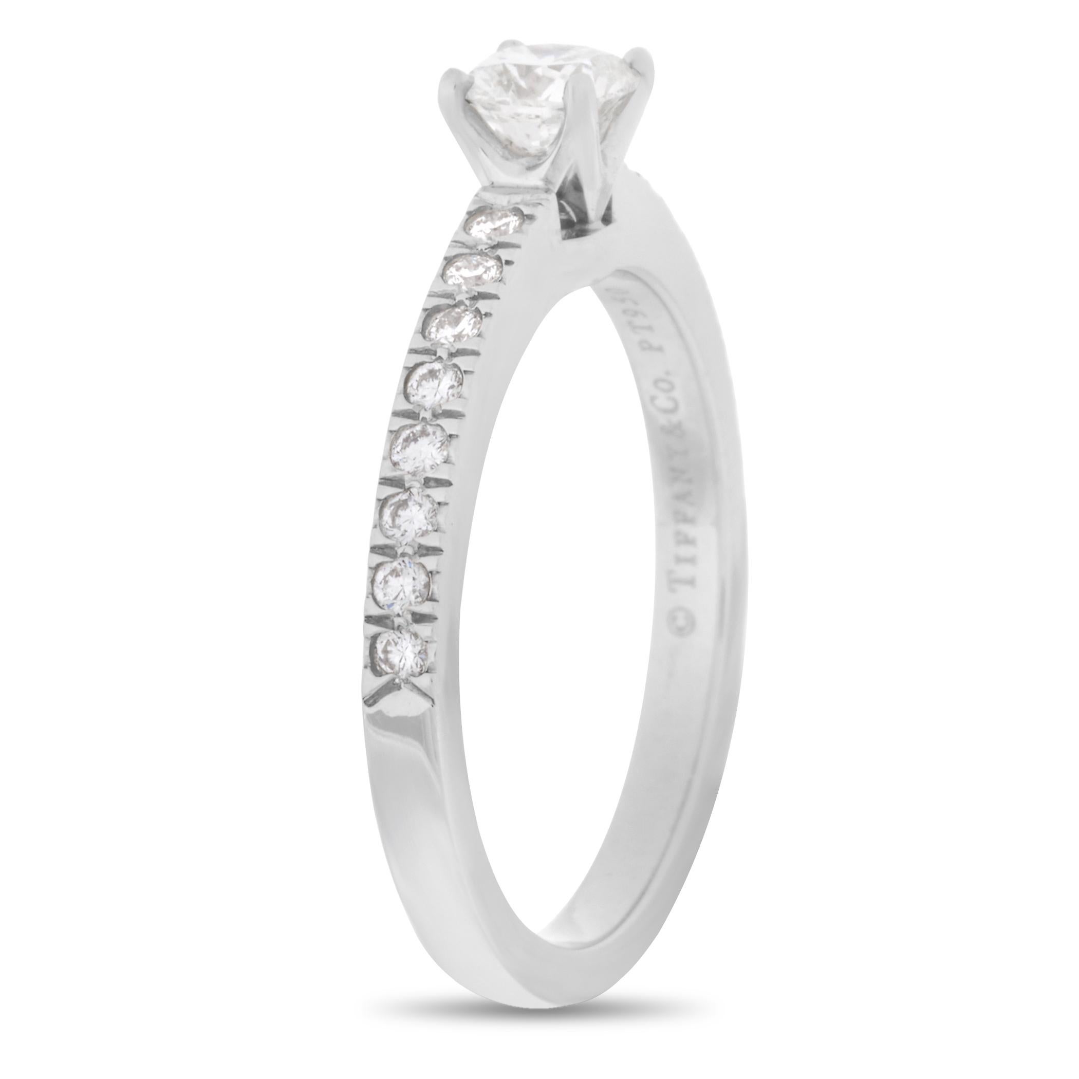 Embellished with a sparkling diamond stone of 0.32 carats in the center, G color VS1 clarity, and multiple diamonds on the band, this gorgeous platinum ring is made by Tiffany & Co. The ring weighs 4 grams and boasts band thickness of 2 mm.

This