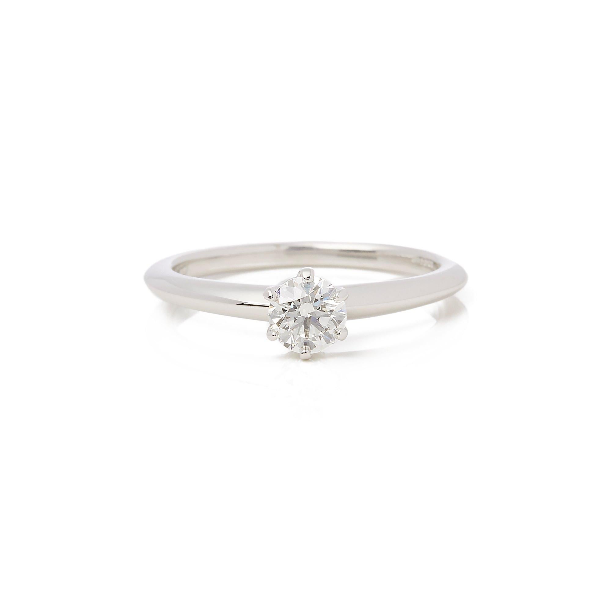 This Ring by Tiffany & Co is from their Classic Tiffany Setting Collection and features One Round Brilliant Cut Diamond Totalling 0.35cts, H Colour VVS1 Clarity. Mounted in Platinum. Finger Size UK J 1/2, EU Size 49, USA Size 5. Complete with