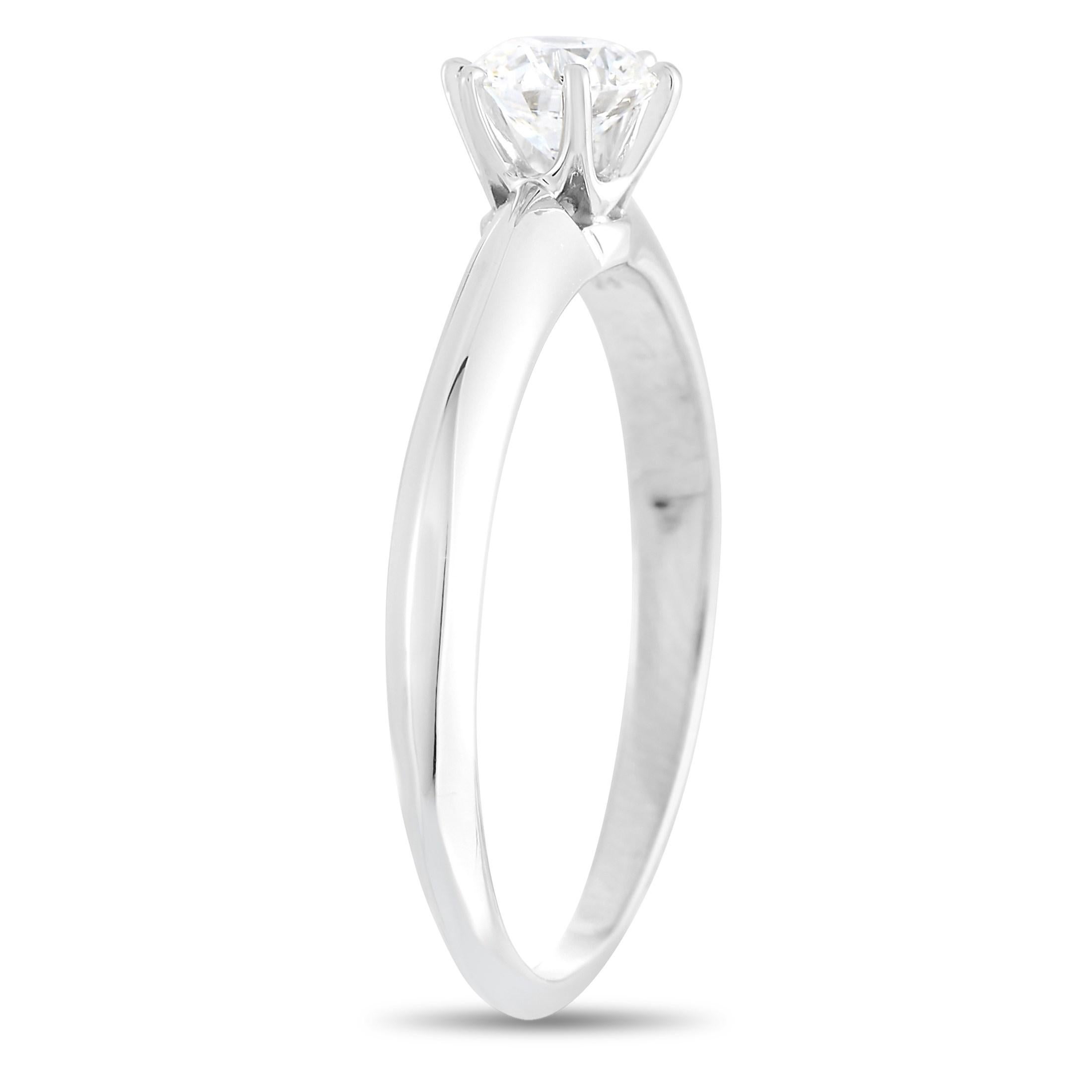 The Tiffany & Co. Platinum 0.41 ct Diamond E-VVS1 Engagement Ring is characterized by one round brilliant diamond perched on a six-prong setting on a simple 2mm band with knife-edge detail. Simple but significant, this design has set the standard