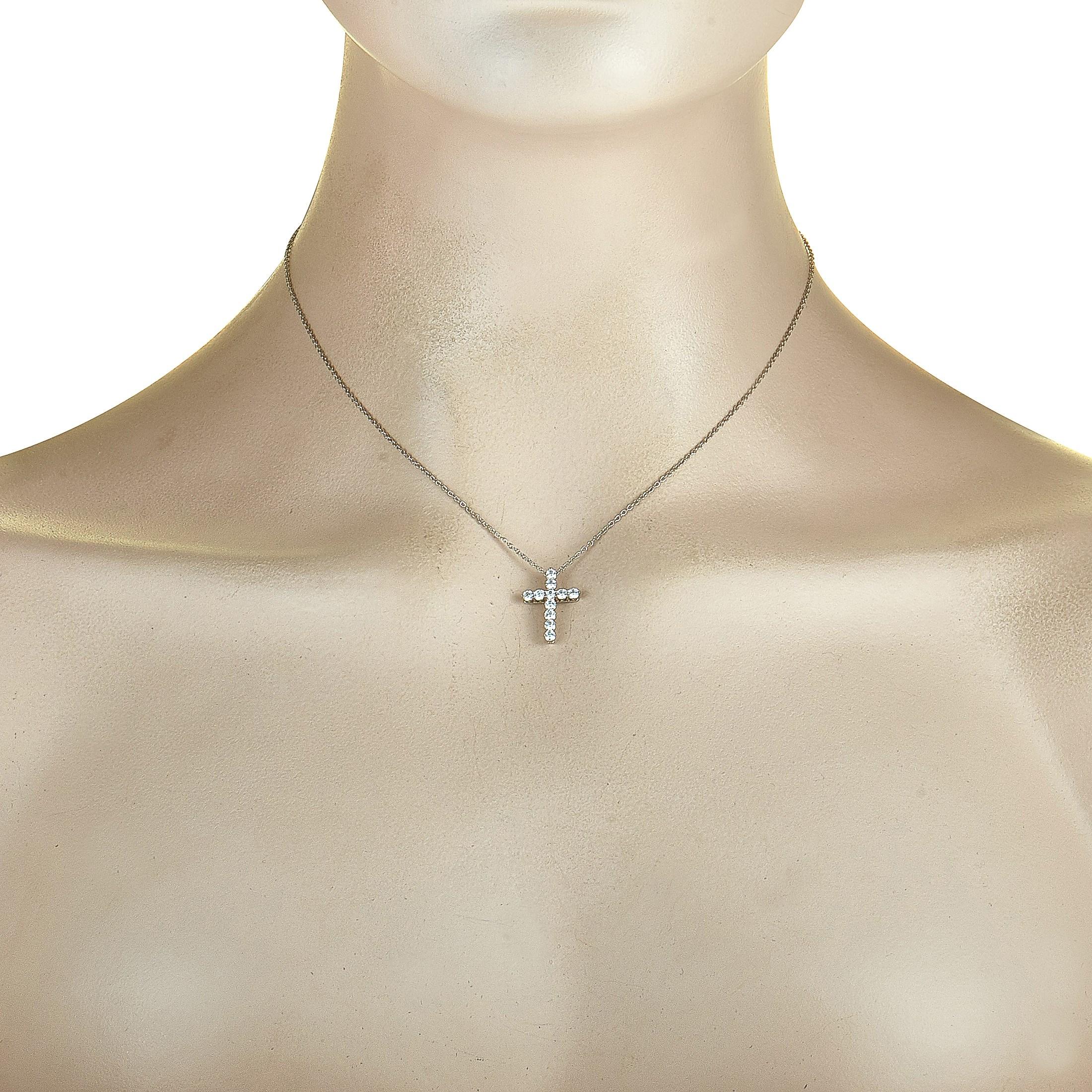 This Tiffany & Co. necklace is crafted from platinum, featuring a 16” chain with spring ring closure and a cross pendant that measures 0.70” in length and 0.50” in width. The necklace is set with a total of 0.42 carats of diamonds that boast grade F