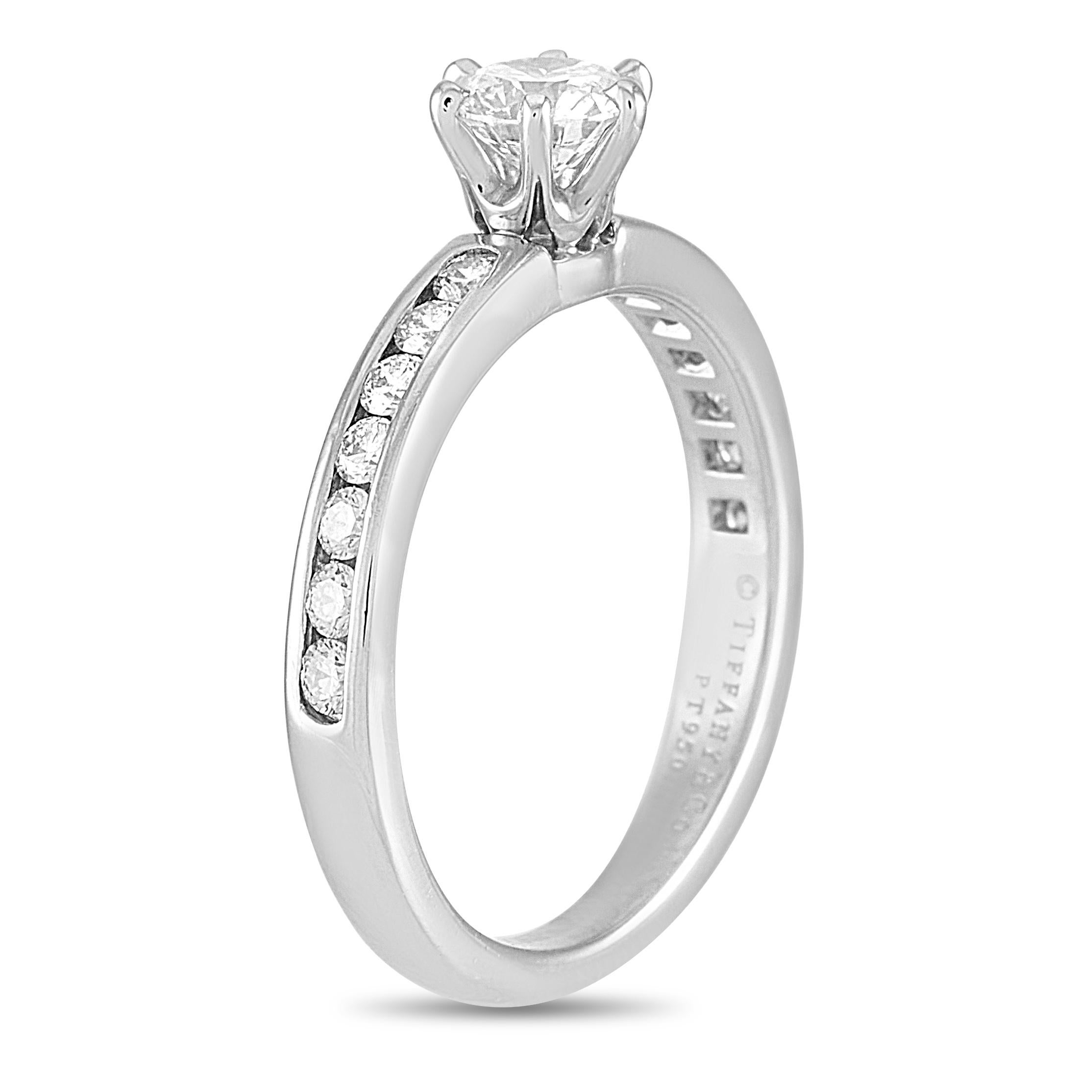 This Tiffany & Co. engagement ring is crafted from platinum and weighs 3.3 grams. It boasts band thickness of 3 mm and top height of 5 mm, while top dimensions measure 5 by 17 mm. The ring is set with a total of 0.54 carats of diamonds – the center