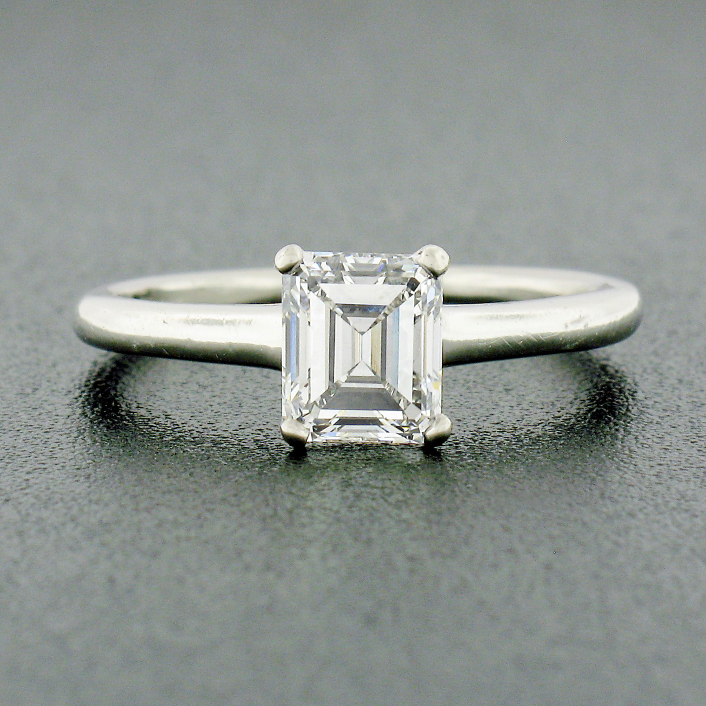 Here we have a classic, vintage, Tiffany & Co. diamond solitaire engagement ring that was crafted from solid platinum. It features a very fine quality, GIA certified, emerald cut diamond weighing exactly 1.06 carats and displays truly magnificent