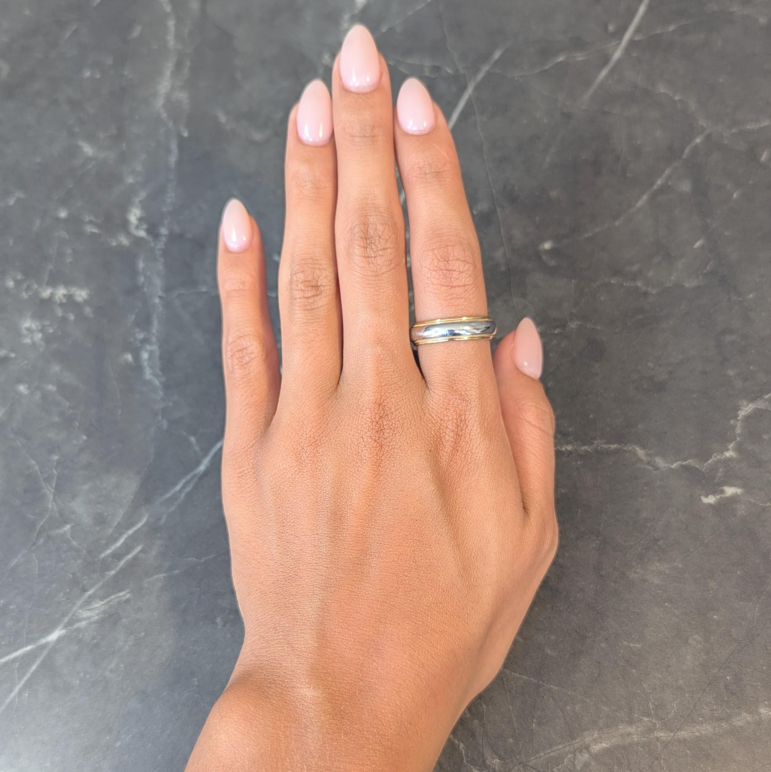Designed as a ridged yellow gold band 
With a curved platinum outer band
Accented by milgrain detailing
With a high polish finish
Stamped for platinum and 18 karat gold
Fully signed for Tiffany & Co.
Circa: 2000s
Ring Size: 9 1/4 and not