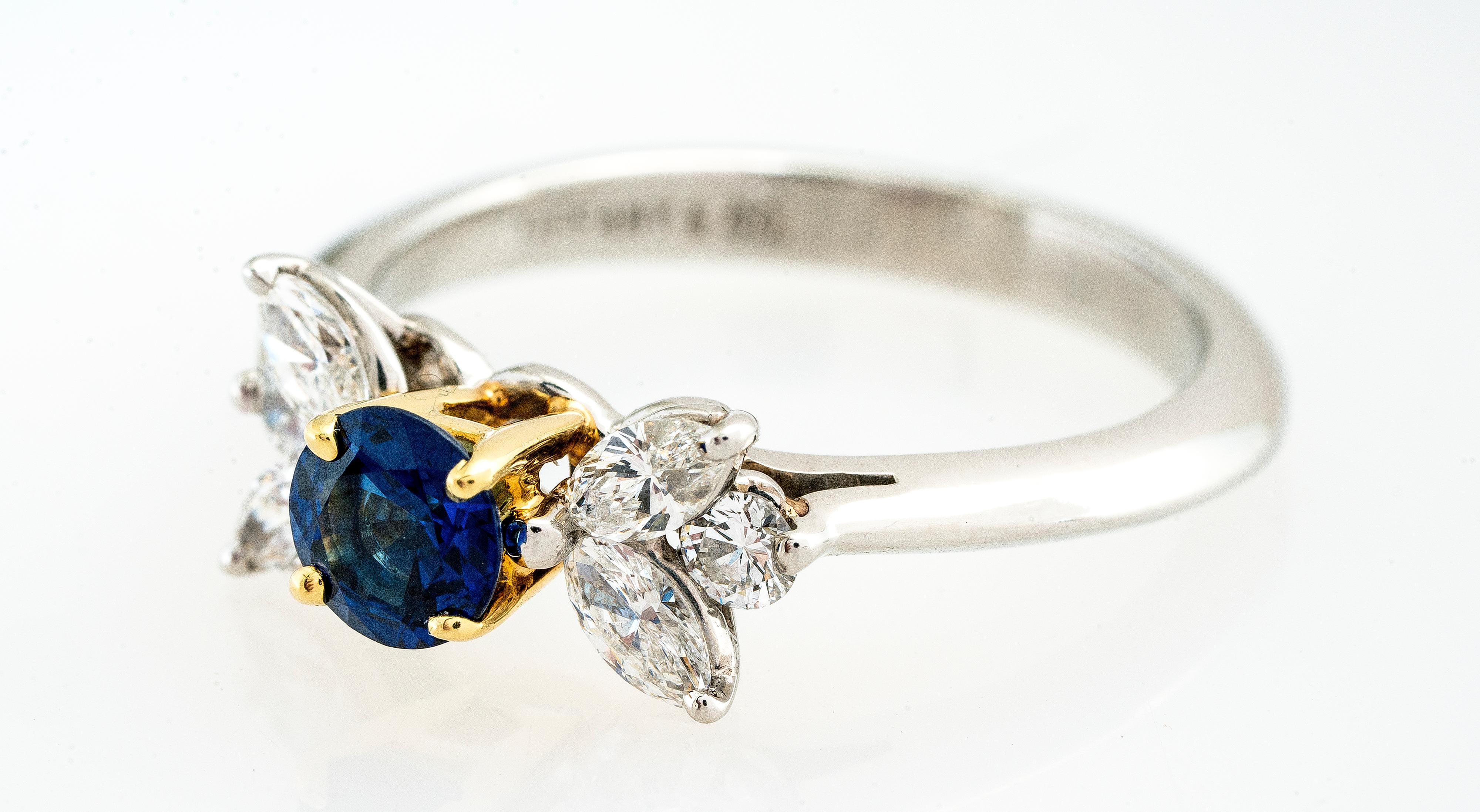 Vintage Tiffany & Co platinum & 18ky blue sapphire and diamond ring from the Victoria collection.  The round blue sapphire weight approximately 0.50 carats (5.16mm) and is prong set in 18k yellow gold.  There are 
four marquise diamonds and two